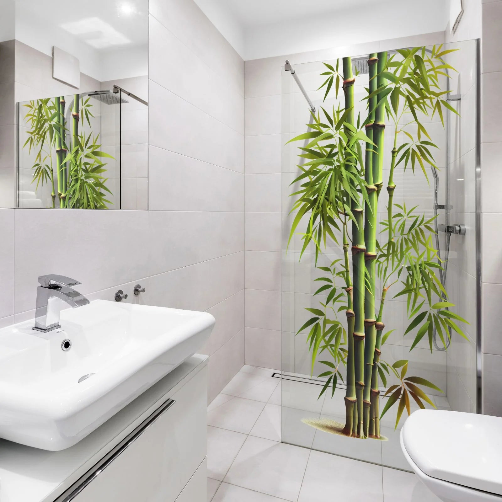 A modern bathroom with a white sink, white toilet, and a glass shower door featuring a large printed bamboo design in green and yellow tones.