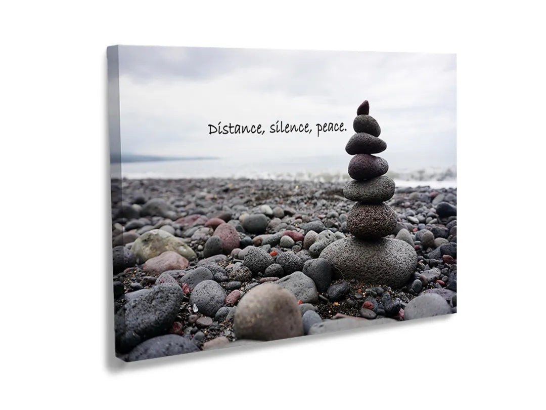 Metalen bord met een afbeelding van een stapel stenen op een kiezelstrand.