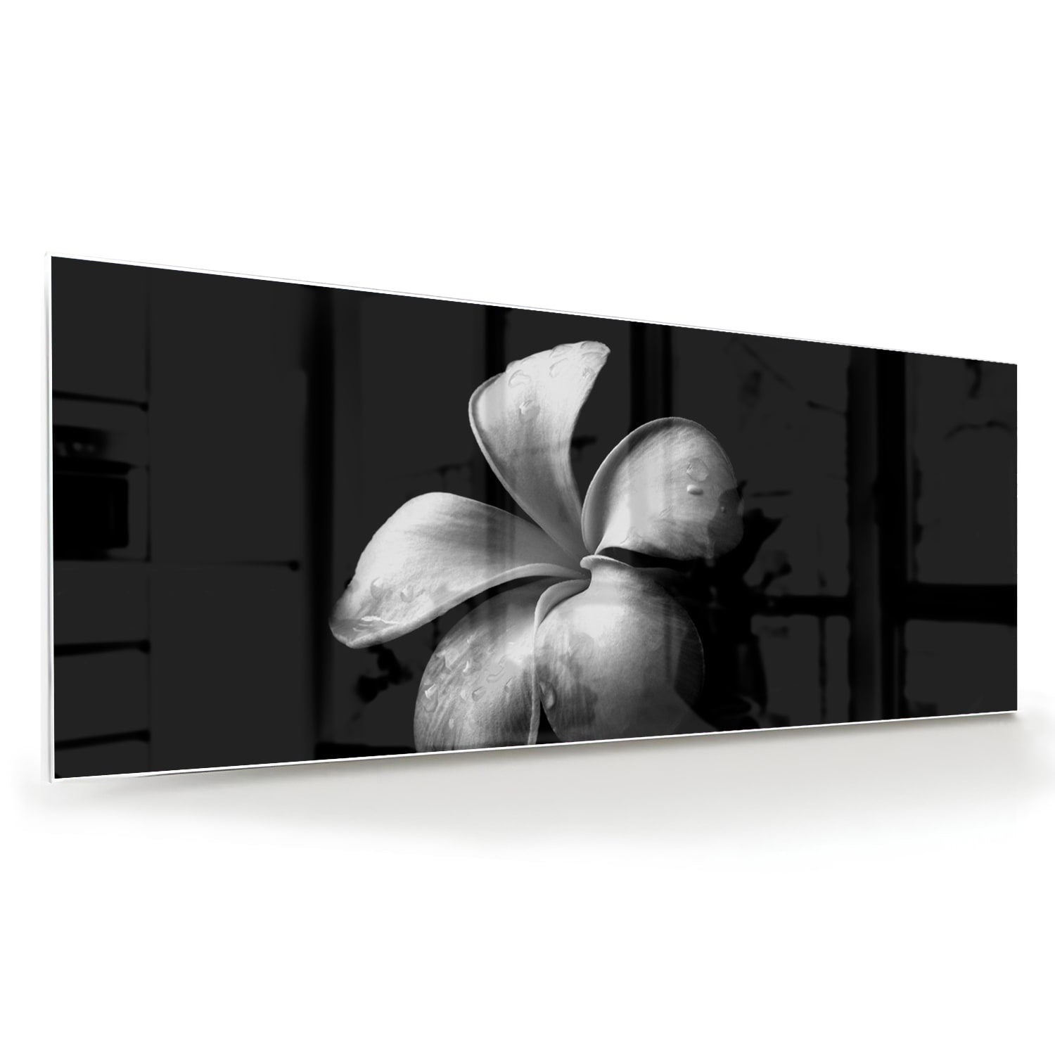 Zwart glazen schilderij met bloemmotief boven een houten kast in een lichte kamer.