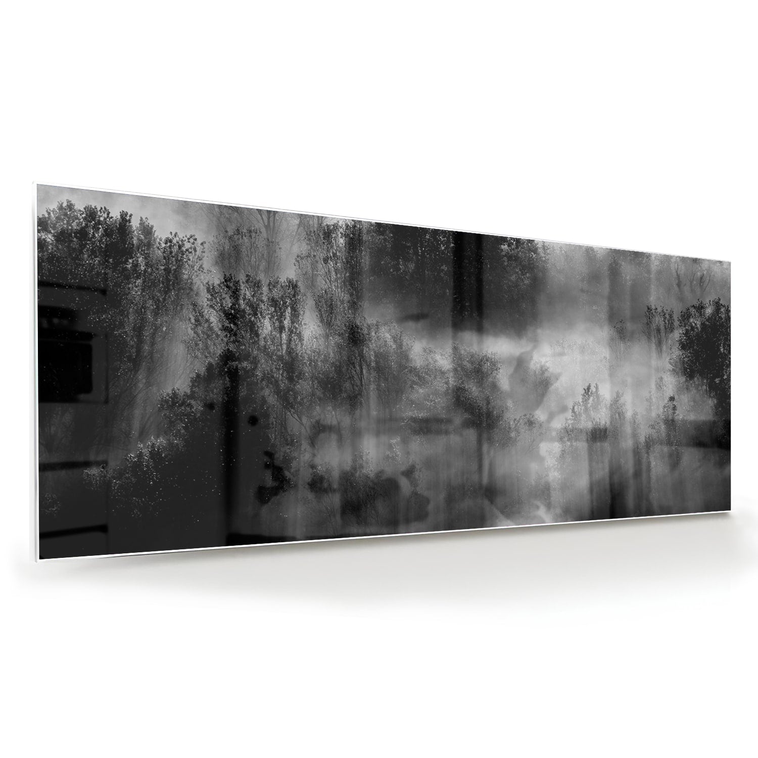 Glazen schilderij met een abstract zwart-wit landschap van bomen in de mist.
