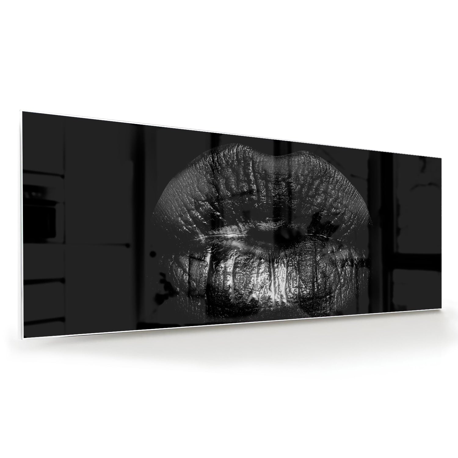 Zwart glazen schilderij met een artistieke lippenprint aan de muur.