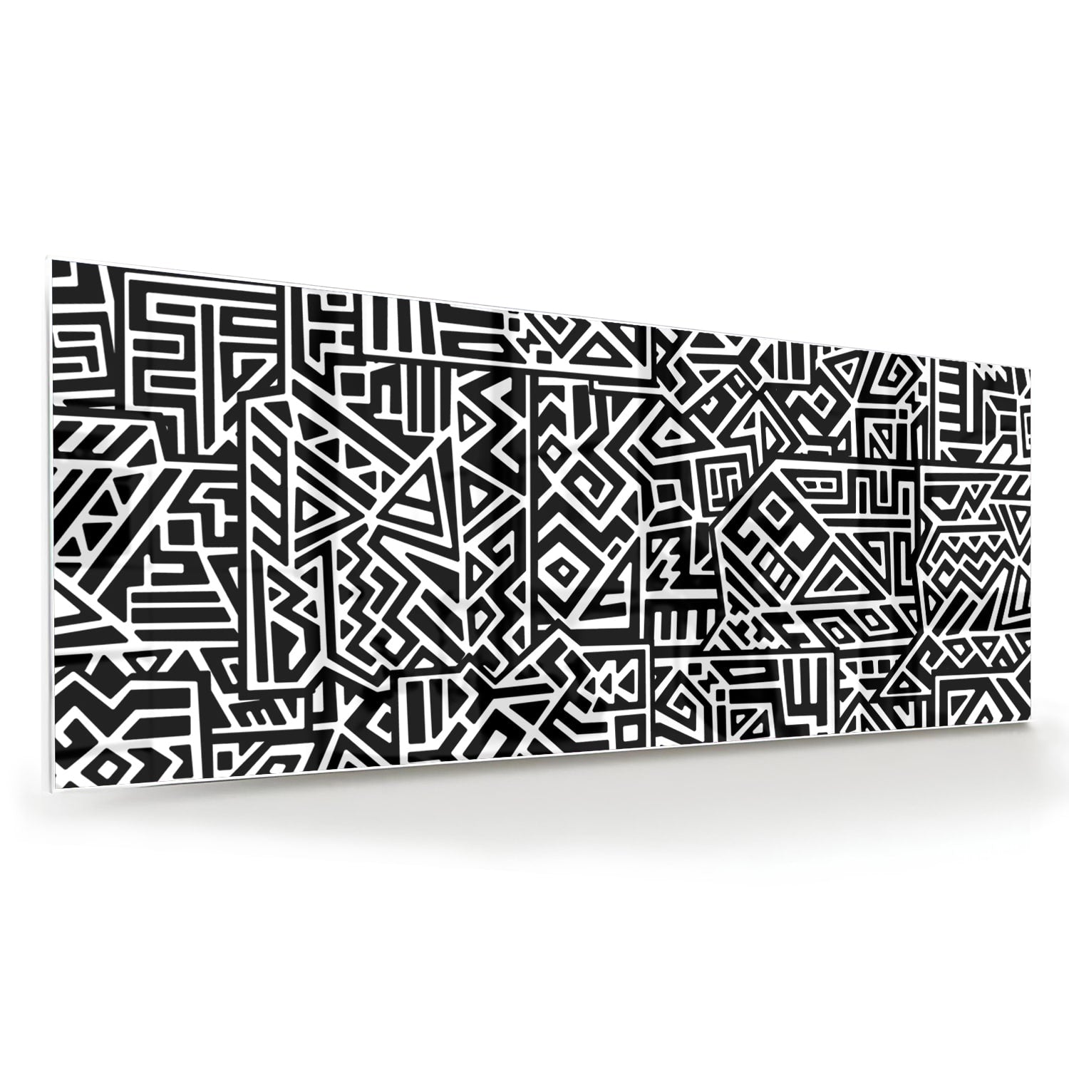 Zwart-wit glazen schilderij met abstract patroon aan de muur in een moderne woonkamer.