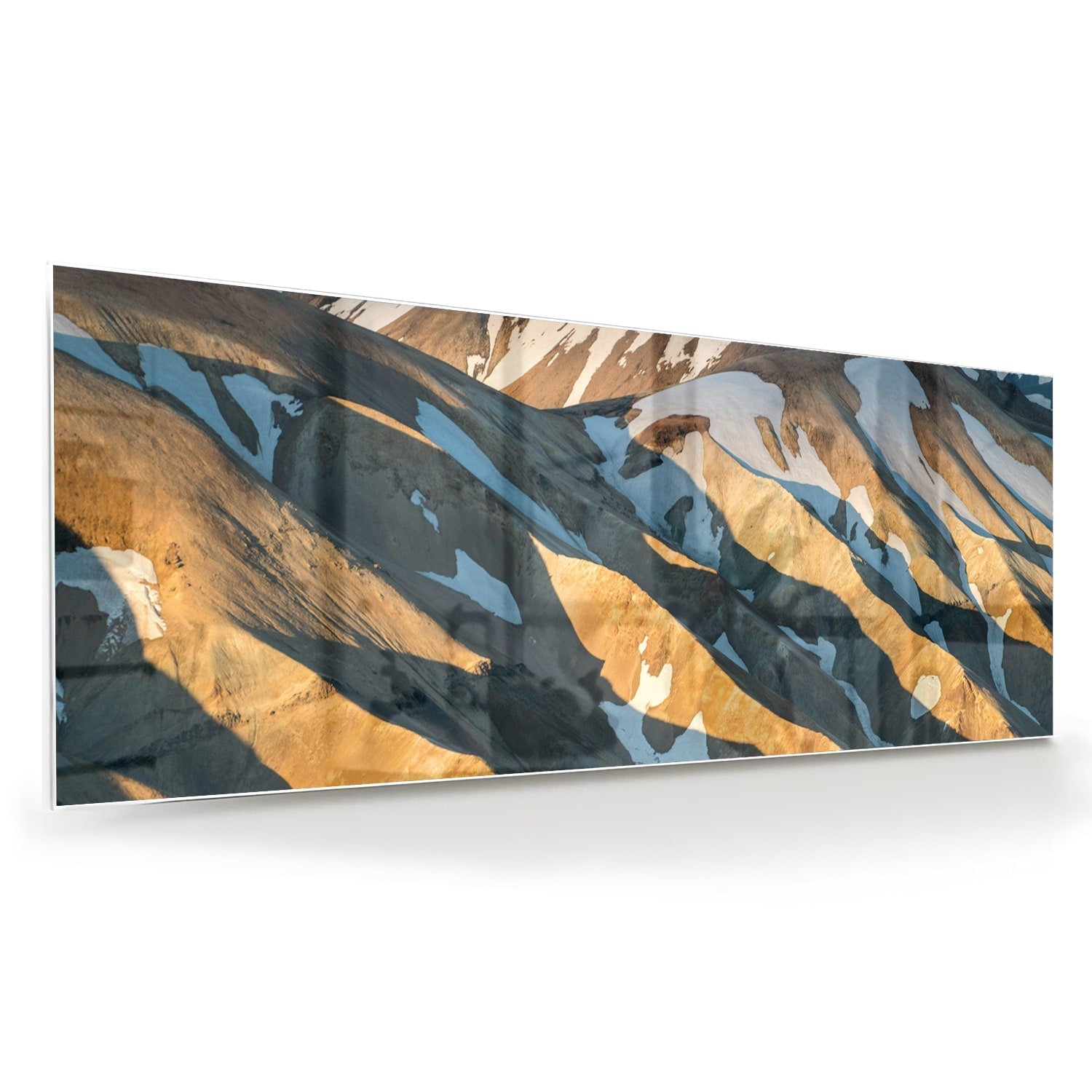 Glazen schilderij van bergen in blauw en goud, hanging in een stijlvolle kamer.