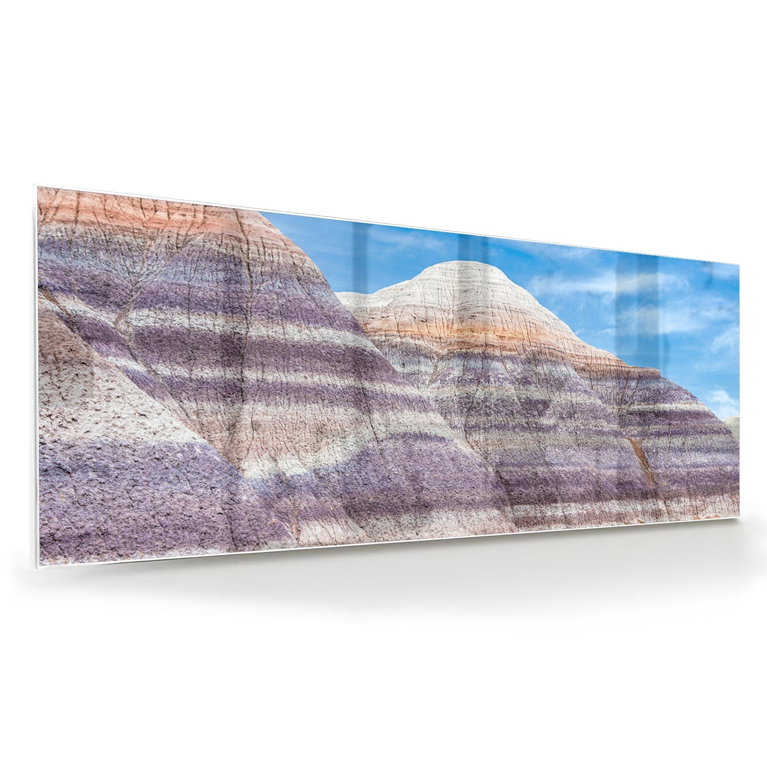 Glazen schilderij van bergen met een blauwe lucht in een moderne woonkamer.