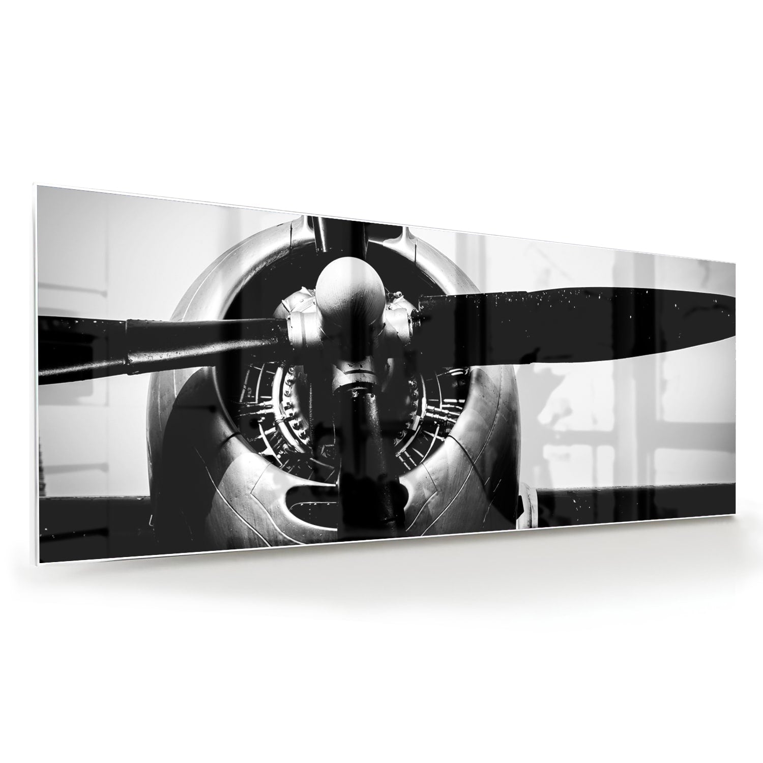Zwart-wit glazen schilderij van een vintage vliegtuigpropeller tegen een lichte muur.