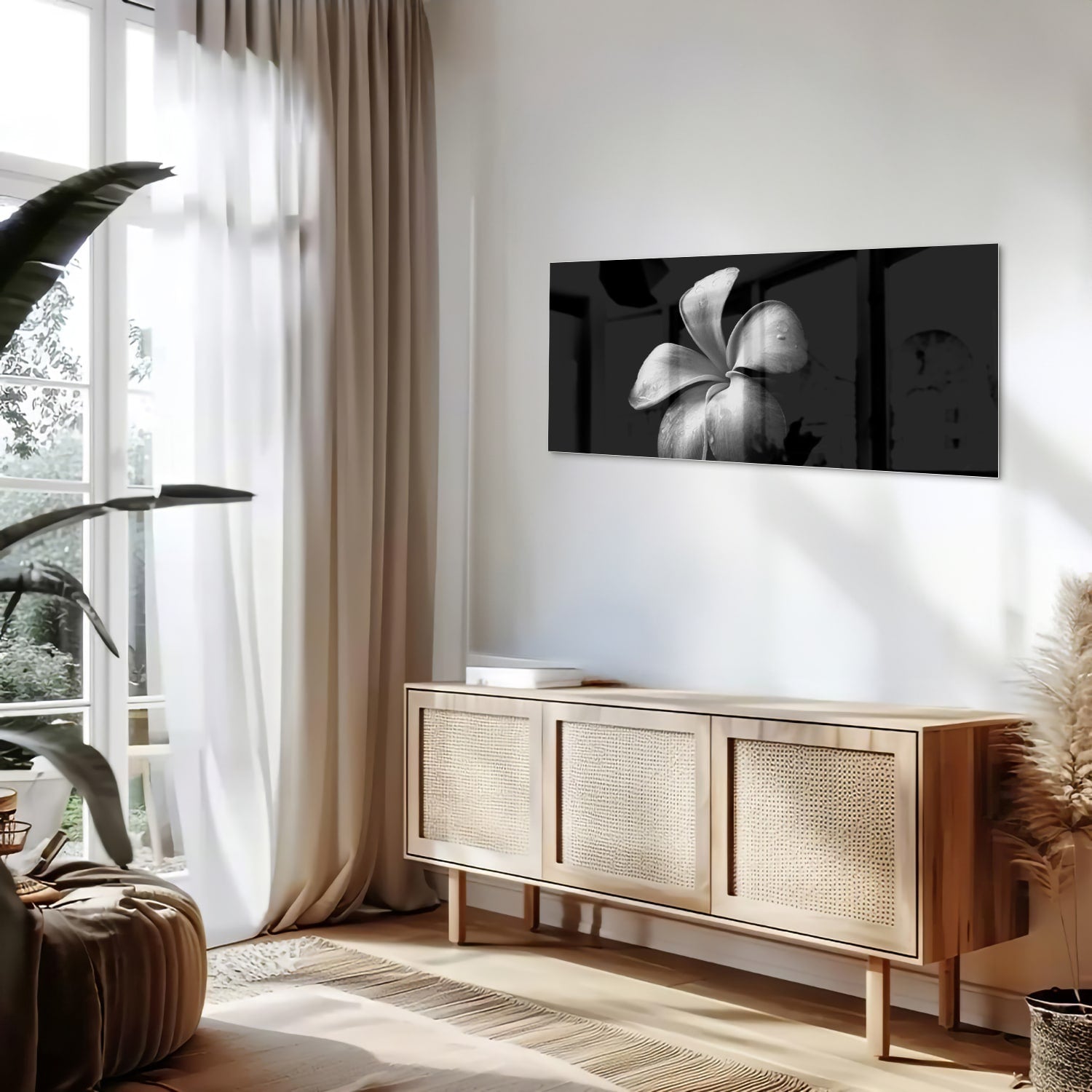 Zwart glazen schilderij met bloemmotief boven een houten kast in een lichte kamer.