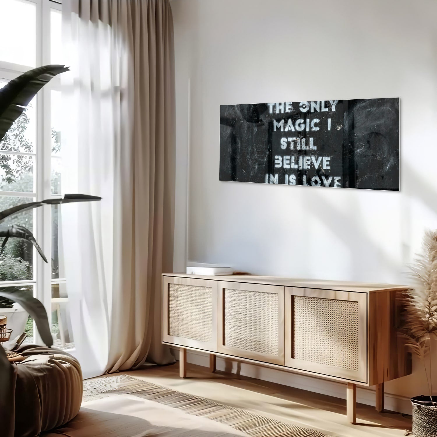 Glazen schilderij met de tekst 'The only magic I still believe in is love', hangt aan de muur in een lichte woonkamer.