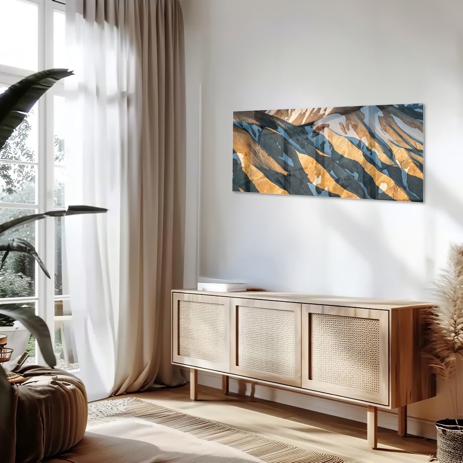 Glazen schilderij van bergen in blauw en goud, hanging in een stijlvolle kamer.