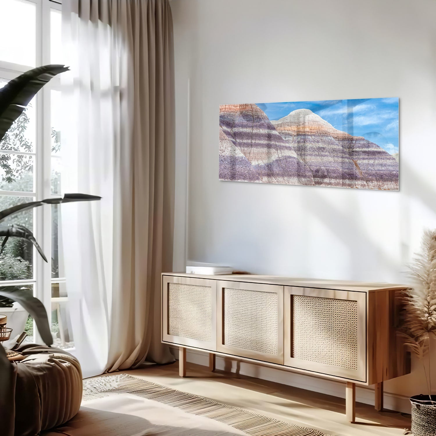 Glazen schilderij van bergen met een blauwe lucht in een moderne woonkamer.