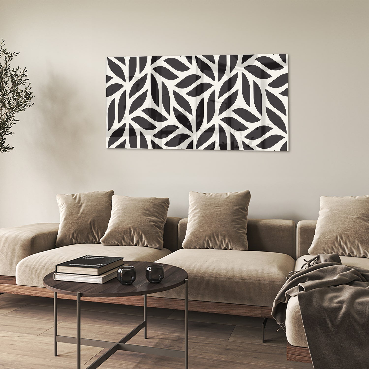 Zwart-wit glazen schilderij met bladerenpatroon aan de muur in een moderne woonkamer.