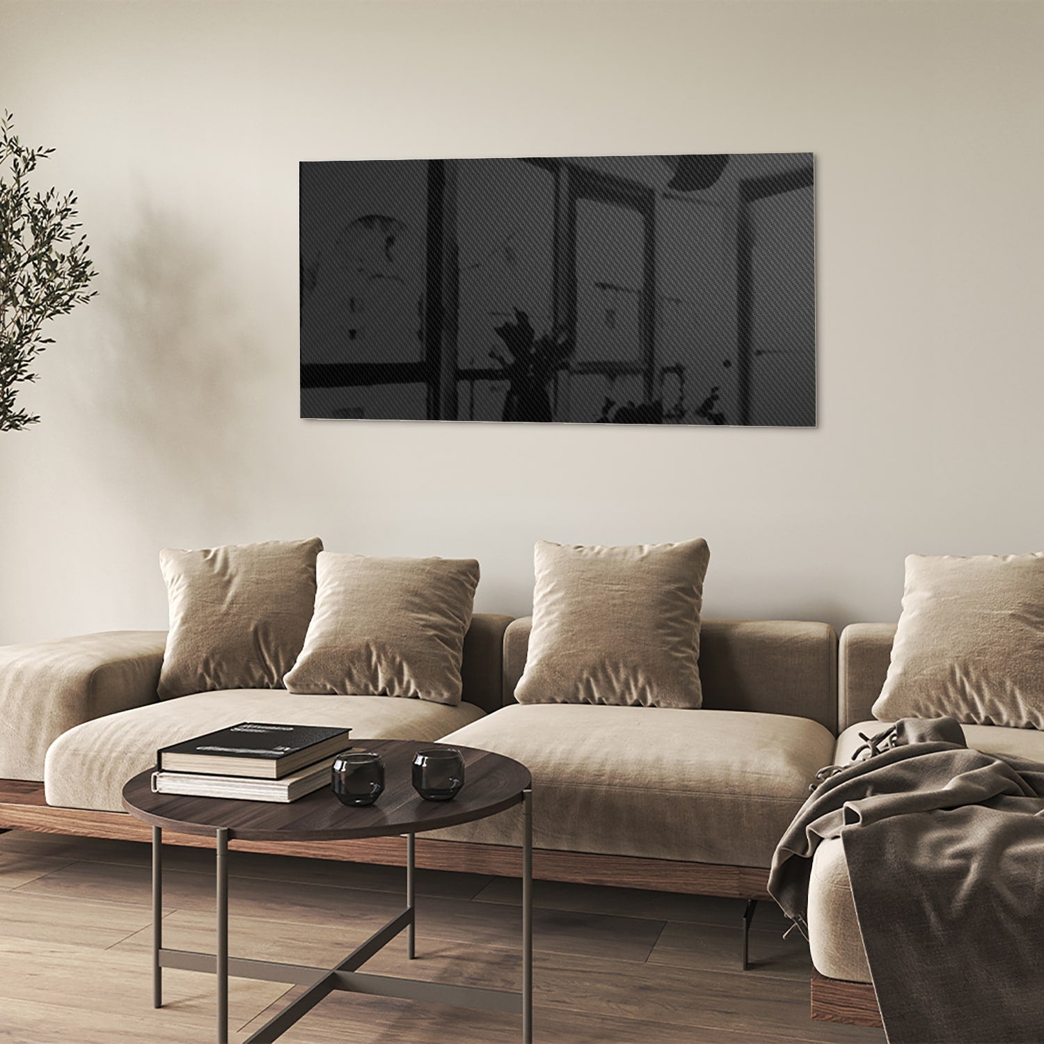 Zwart glazen schilderij hangt boven een houten console in een lichte woonkamer.