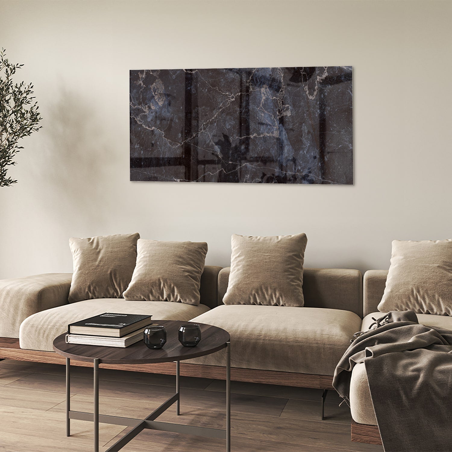 Glazen schilderij met donker marmerlook aan een lichte muur in een moderne woonkamer.