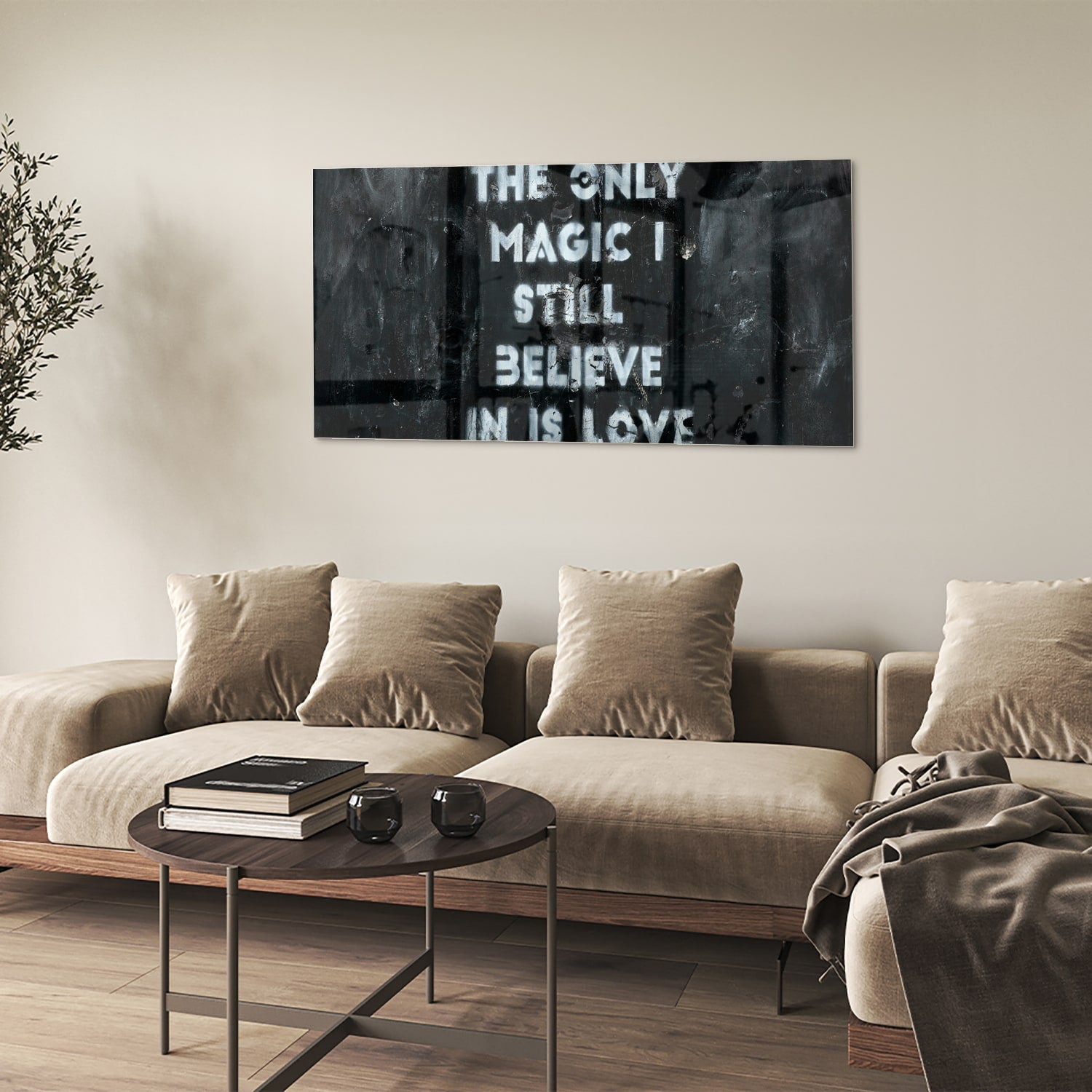 Glazen schilderij met de tekst 'The only magic I still believe in is love', hangt aan de muur in een lichte woonkamer.