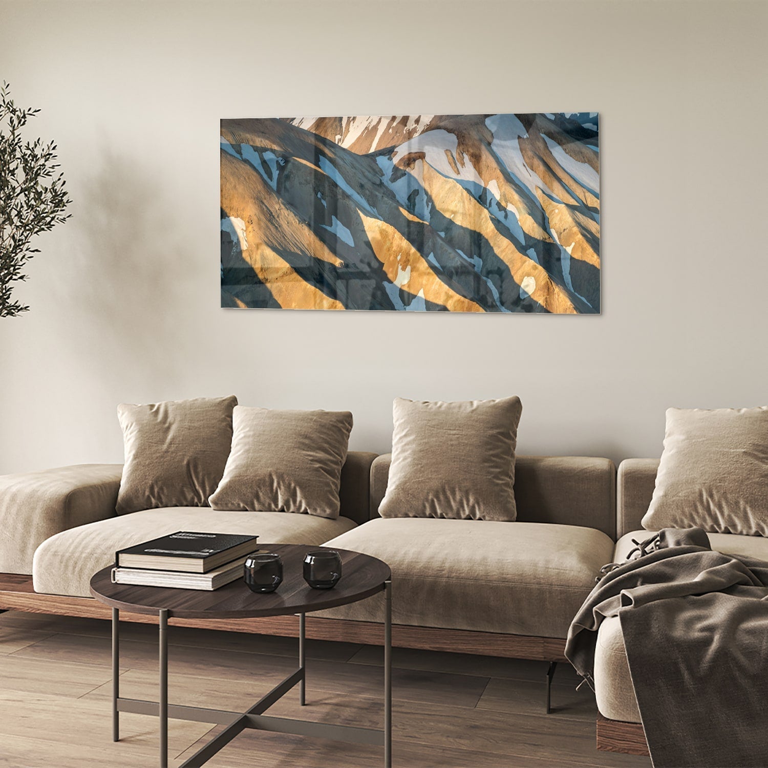 Glazen schilderij van bergen in blauw en goud, hanging in een stijlvolle kamer.