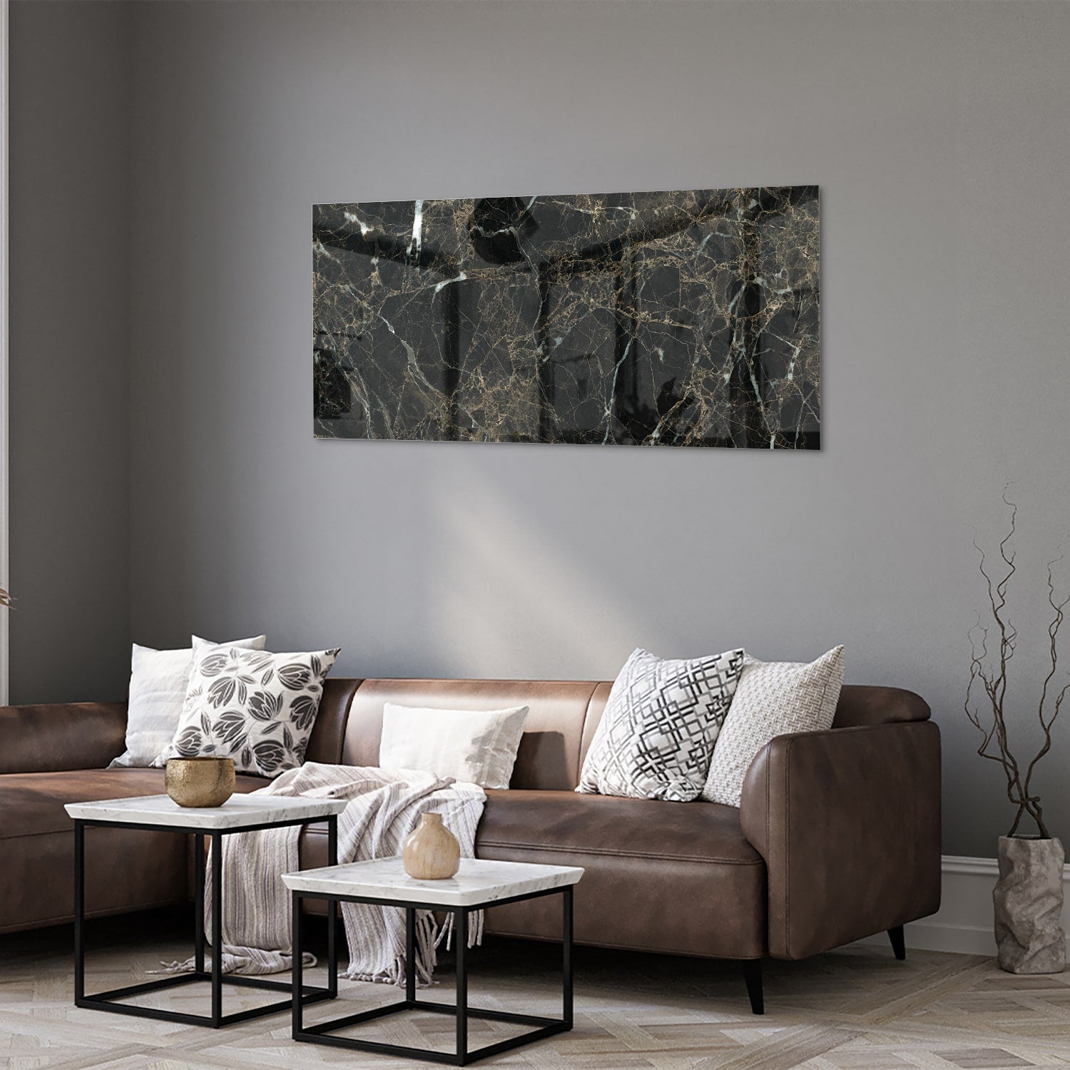 Glazen schilderij van zwart marmer met gouden aderen, hangt boven een moderne meubelstuk.