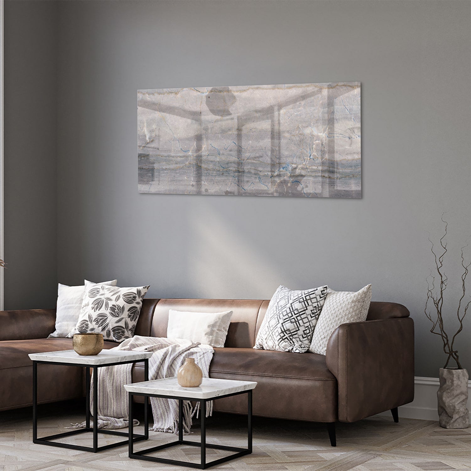 Glazen schilderij in aardetinten hangt aan de muur in een moderne woonkamer.