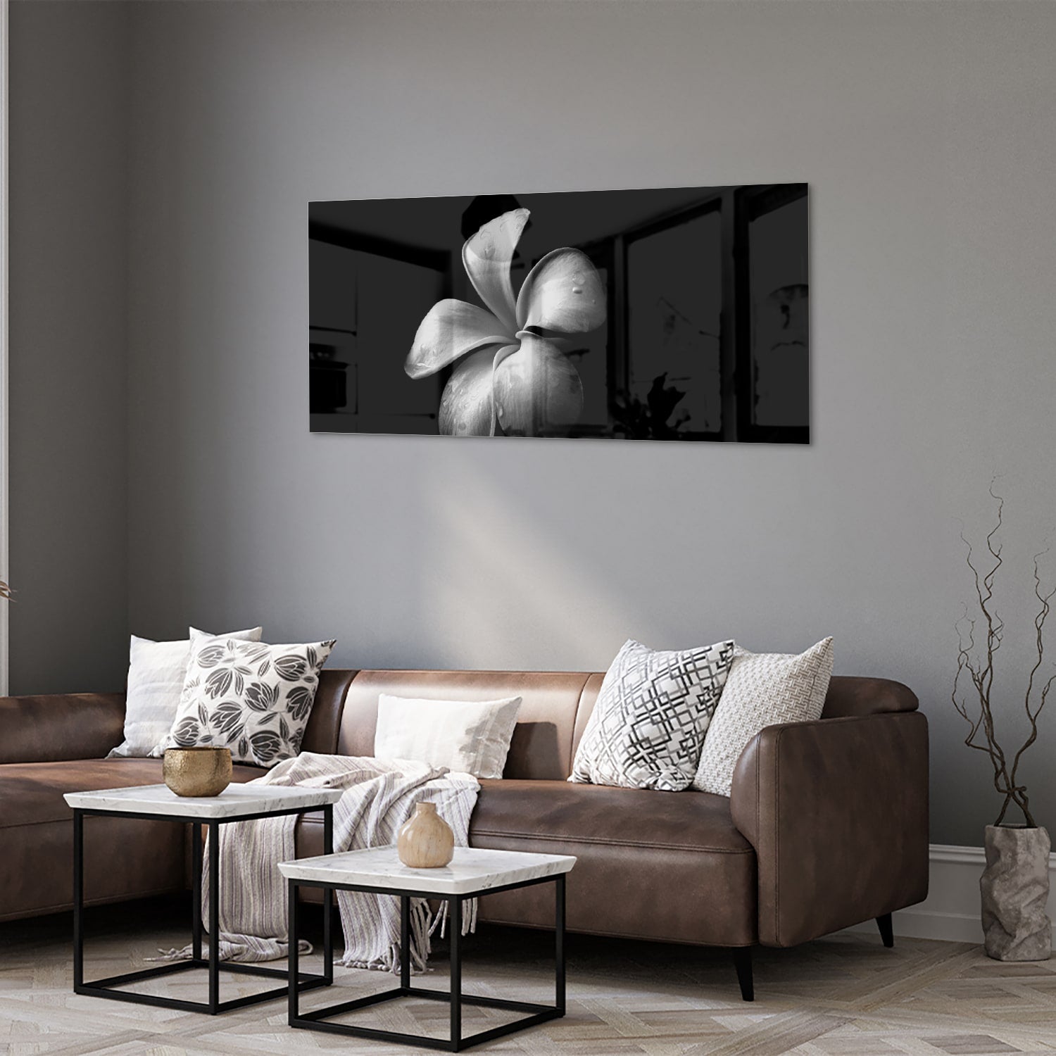 Zwart glazen schilderij met bloemmotief boven een houten kast in een lichte kamer.