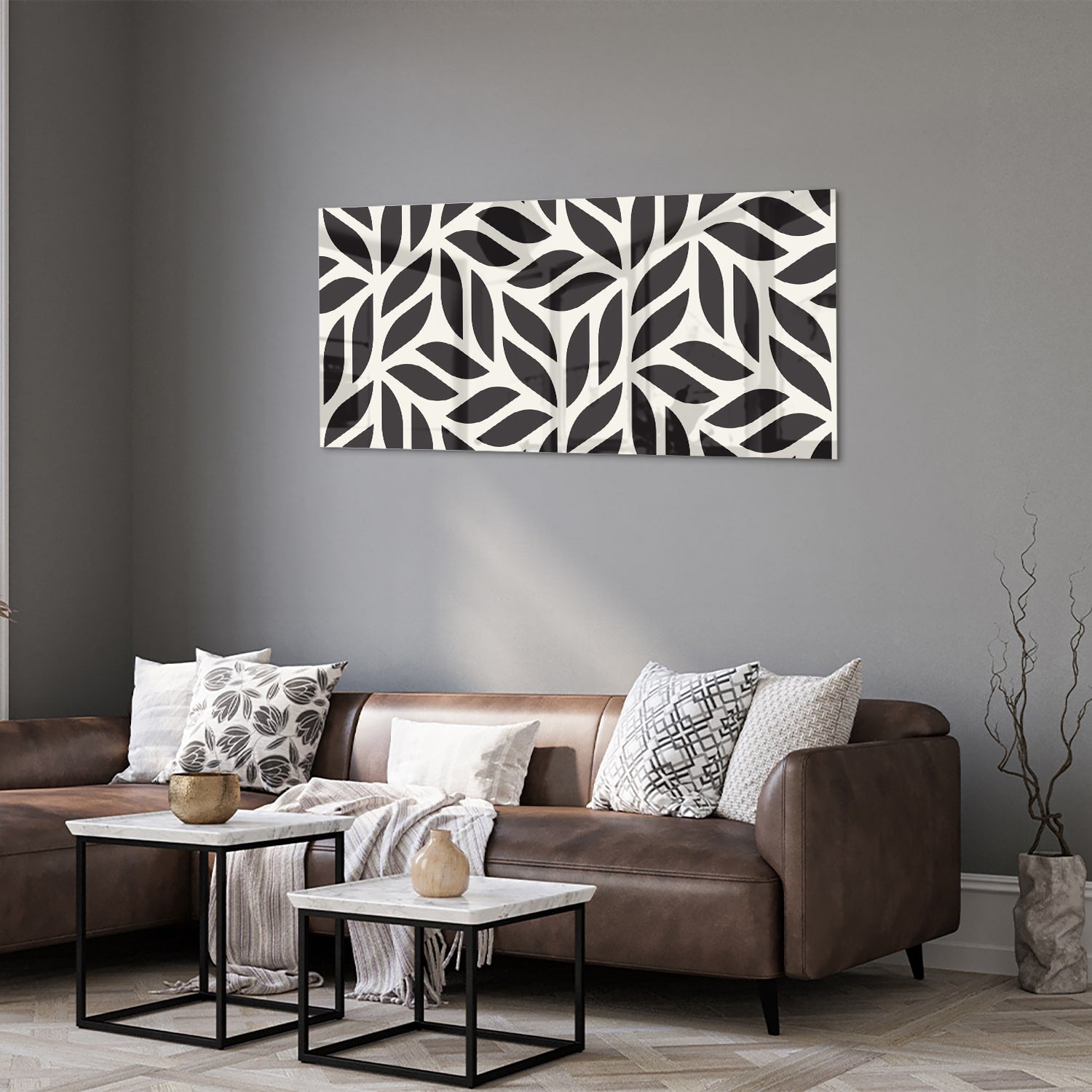 Zwart-wit glazen schilderij met bladerenpatroon aan de muur in een moderne woonkamer.