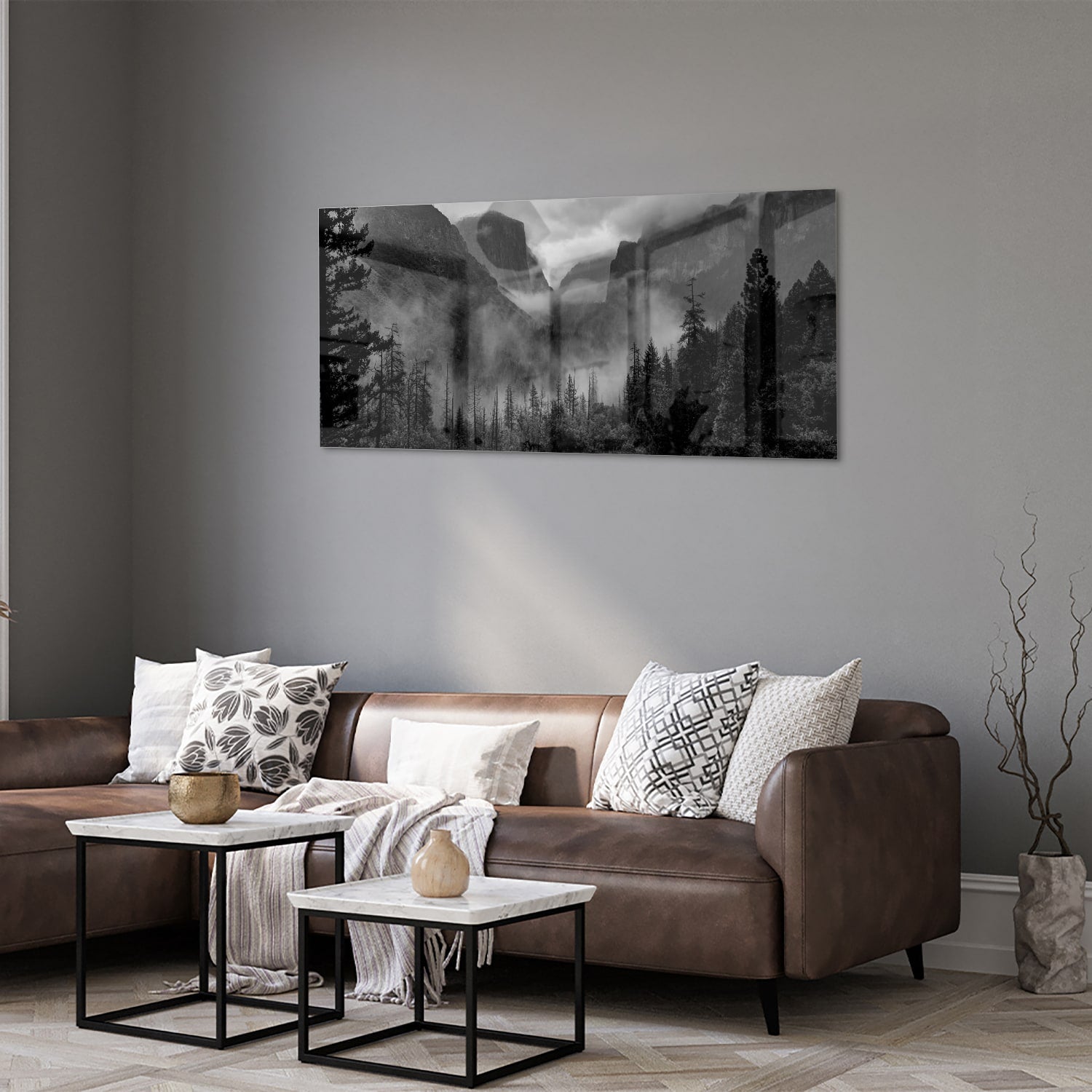Zwart-wit glazen schilderij van een sereen berglandschap aan de muur.