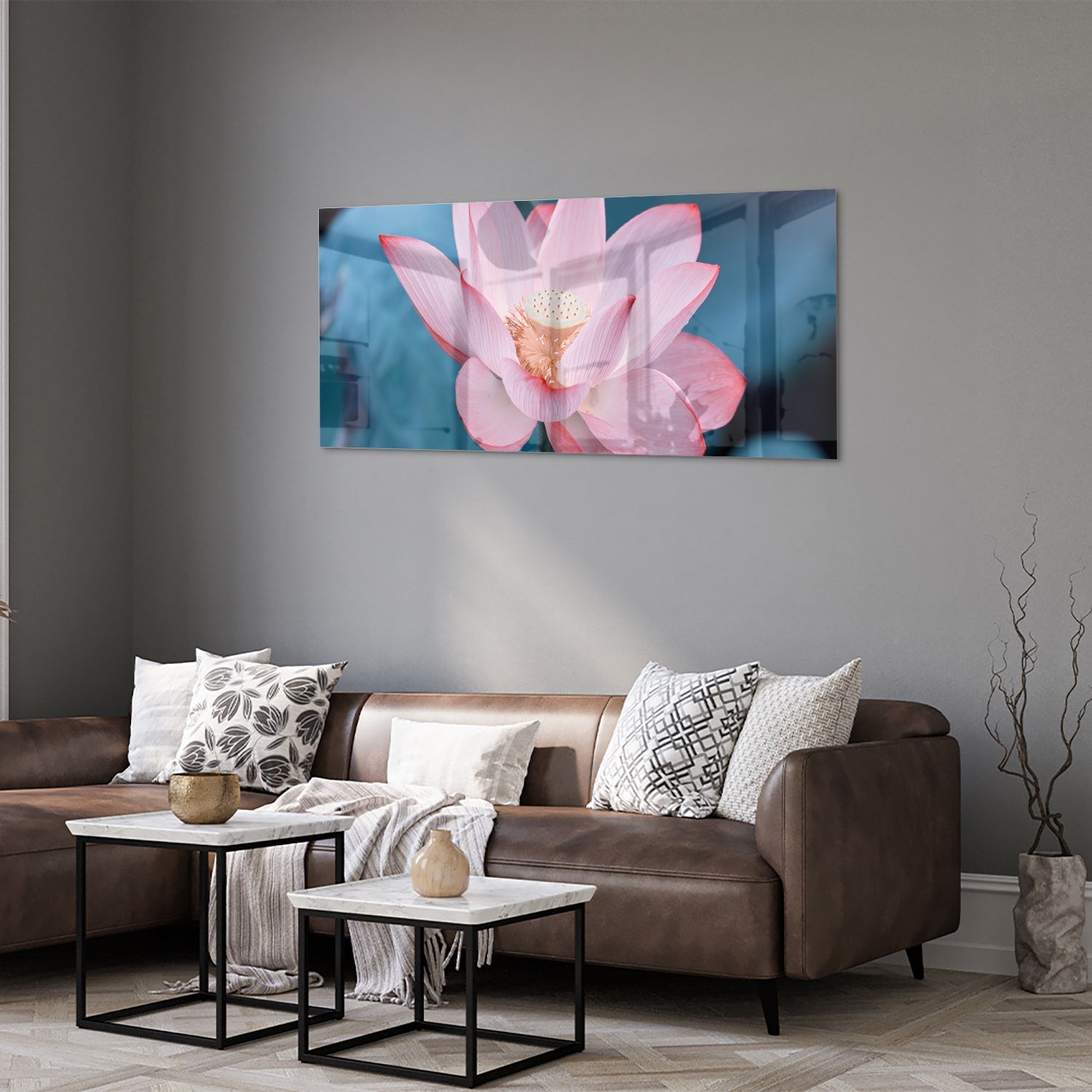 Glazen schilderij van een roze lotus boven een houten meubelstuk in een gezellige woonkamer.