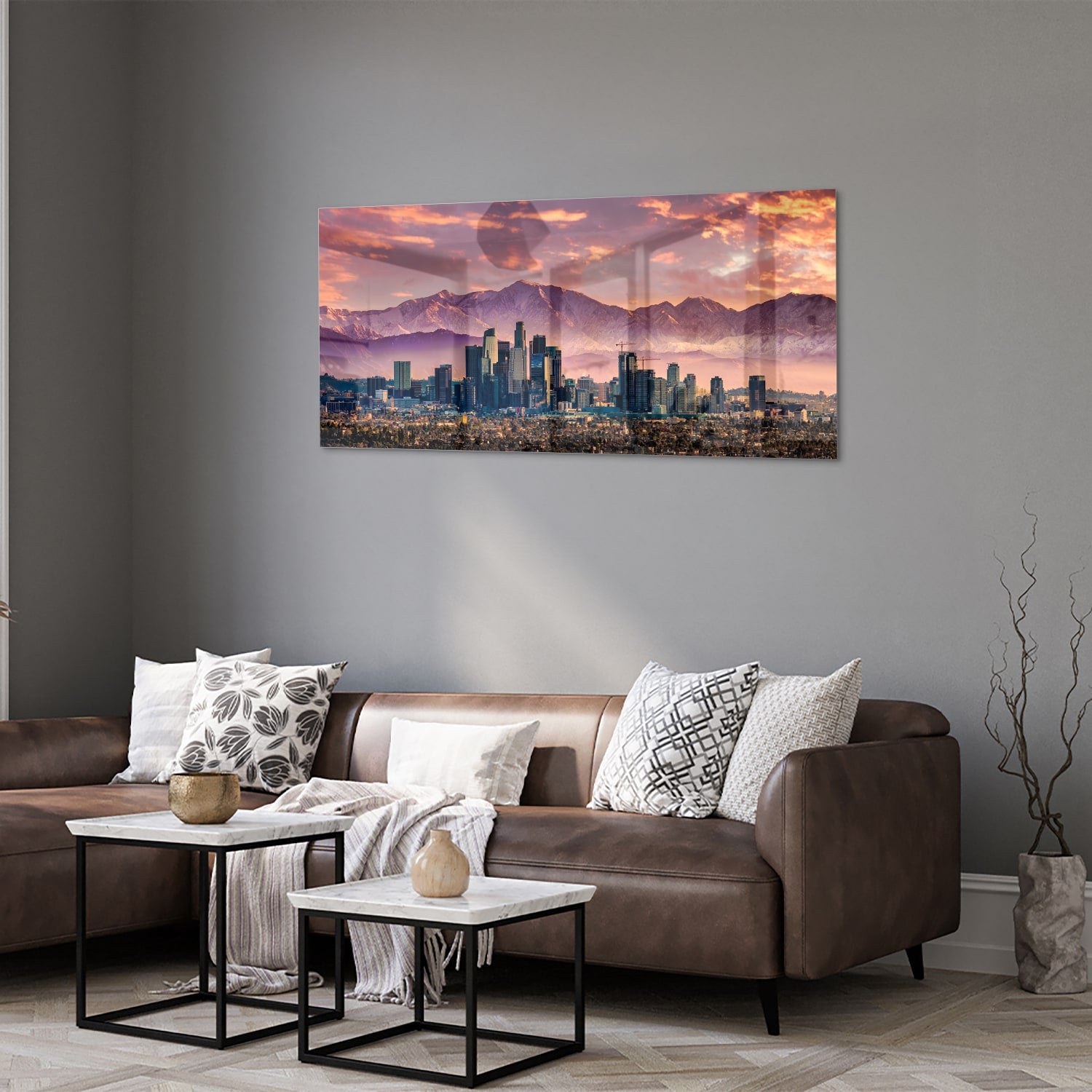Glazen schilderij van een stadspanorama bij zonsondergang met bergen op de achtergrond.