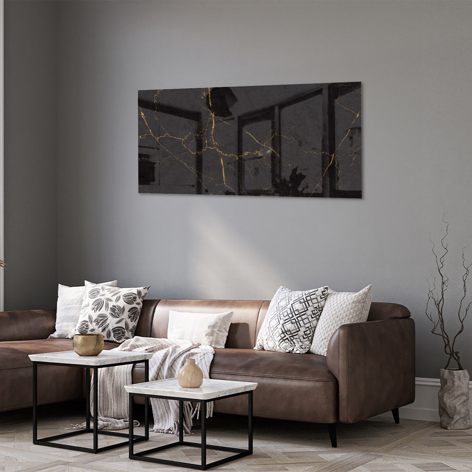 Zwart glazen schilderij met gouden lijnen aan de muur in een moderne woonkamer.