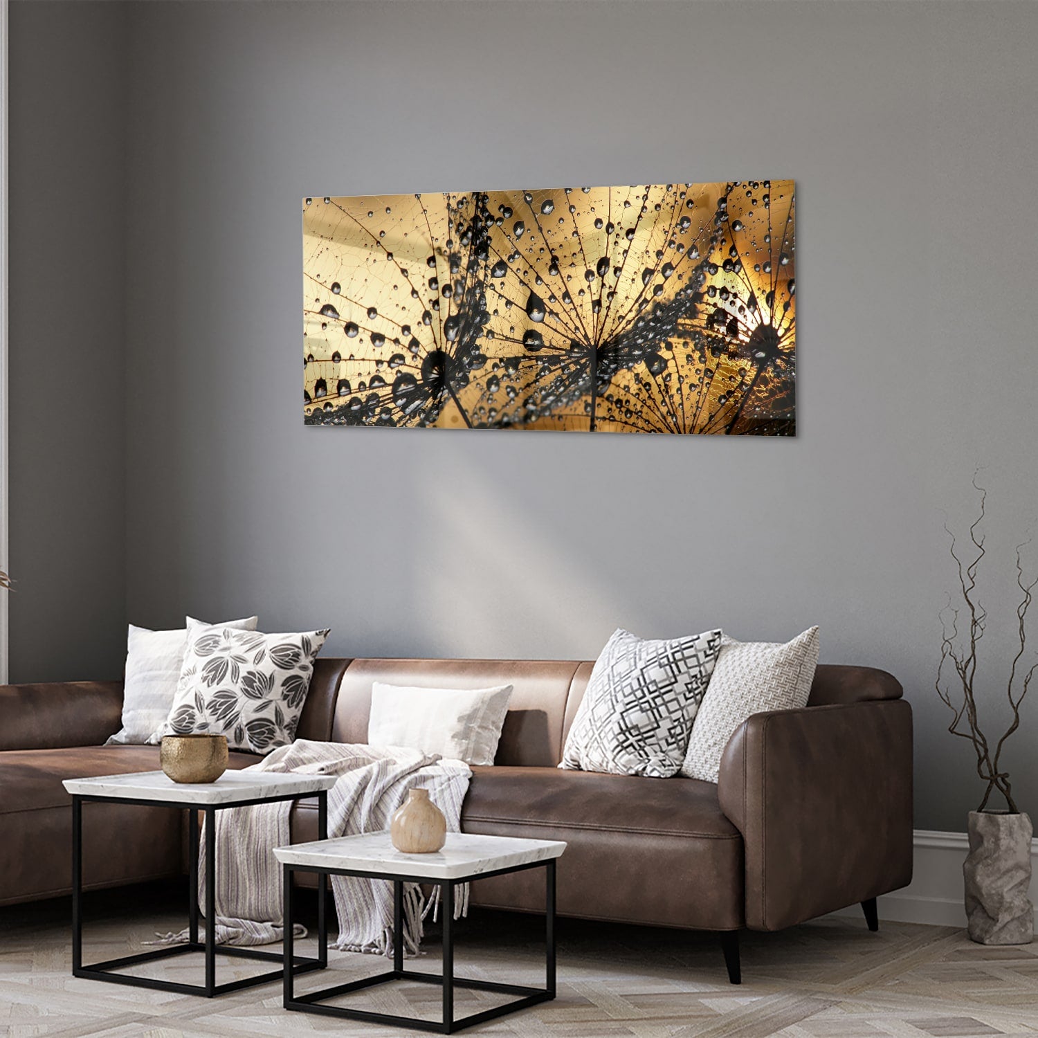 Glazen schilderij met gouden waterdruppels op een lichte muur.