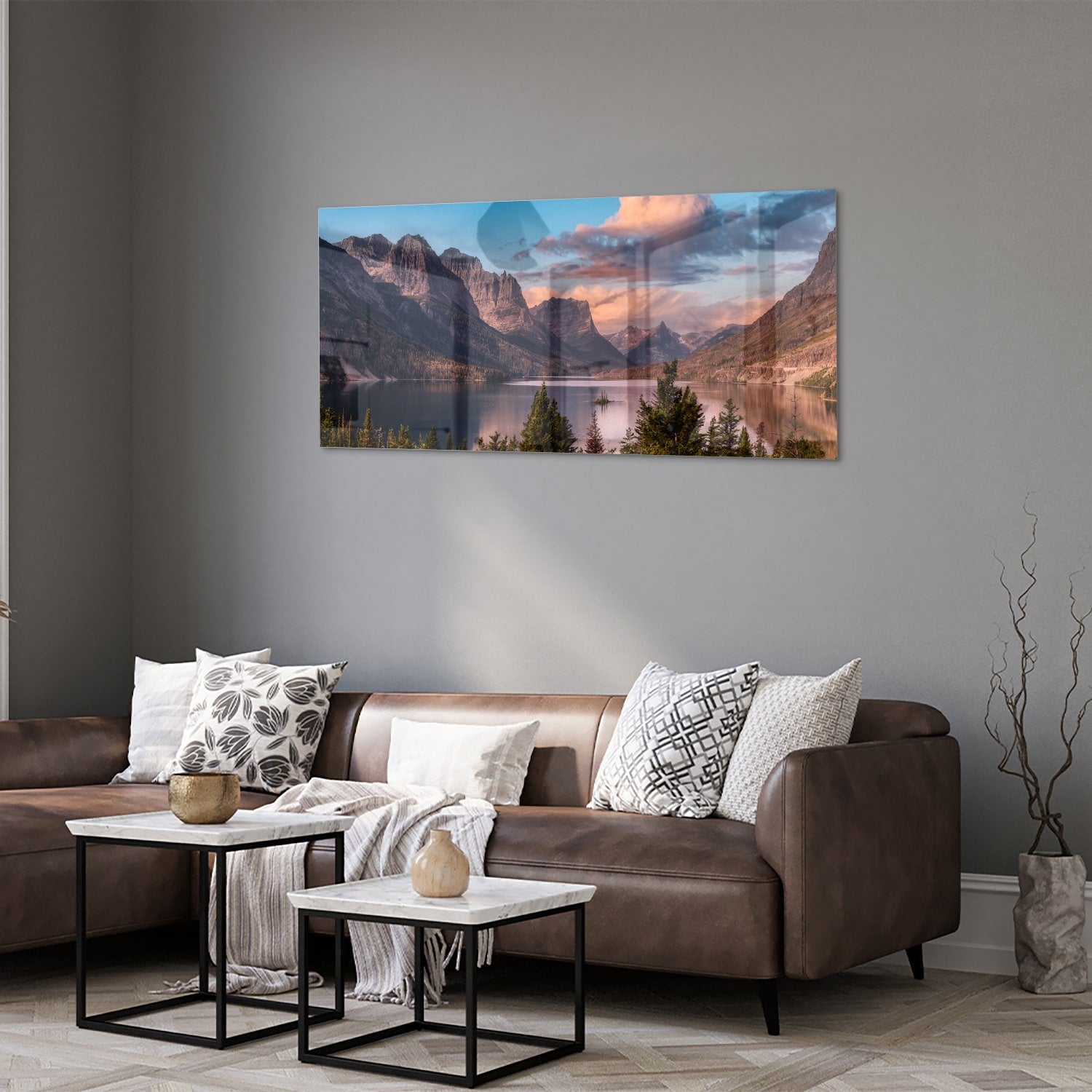 Glazen schilderij van bergen bij zonsopgang in een lichte woonkamer.