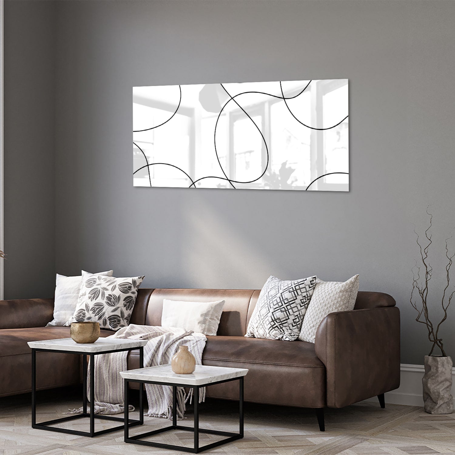 Glazen schilderij met elegante zwarte lijnen in een moderne woonkamer.