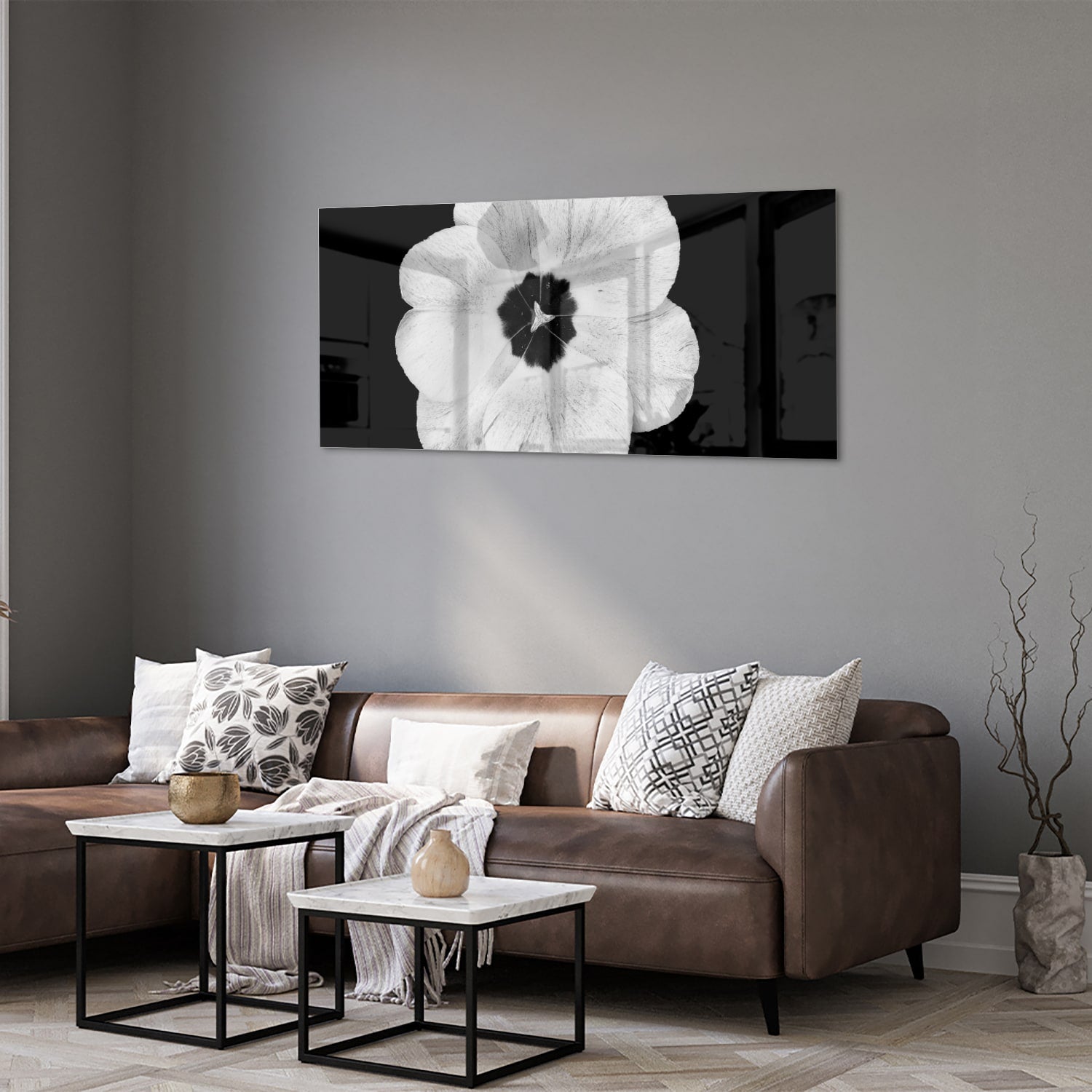 Een glazen schilderij met een witte bloem op een zwarte achtergrond, hangend aan de muur.