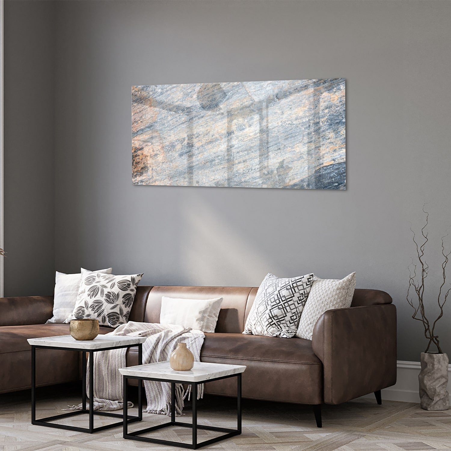 Abstract glazen schilderij met blauwe en oranje tinten aan de muur in een moderne woonkamer.