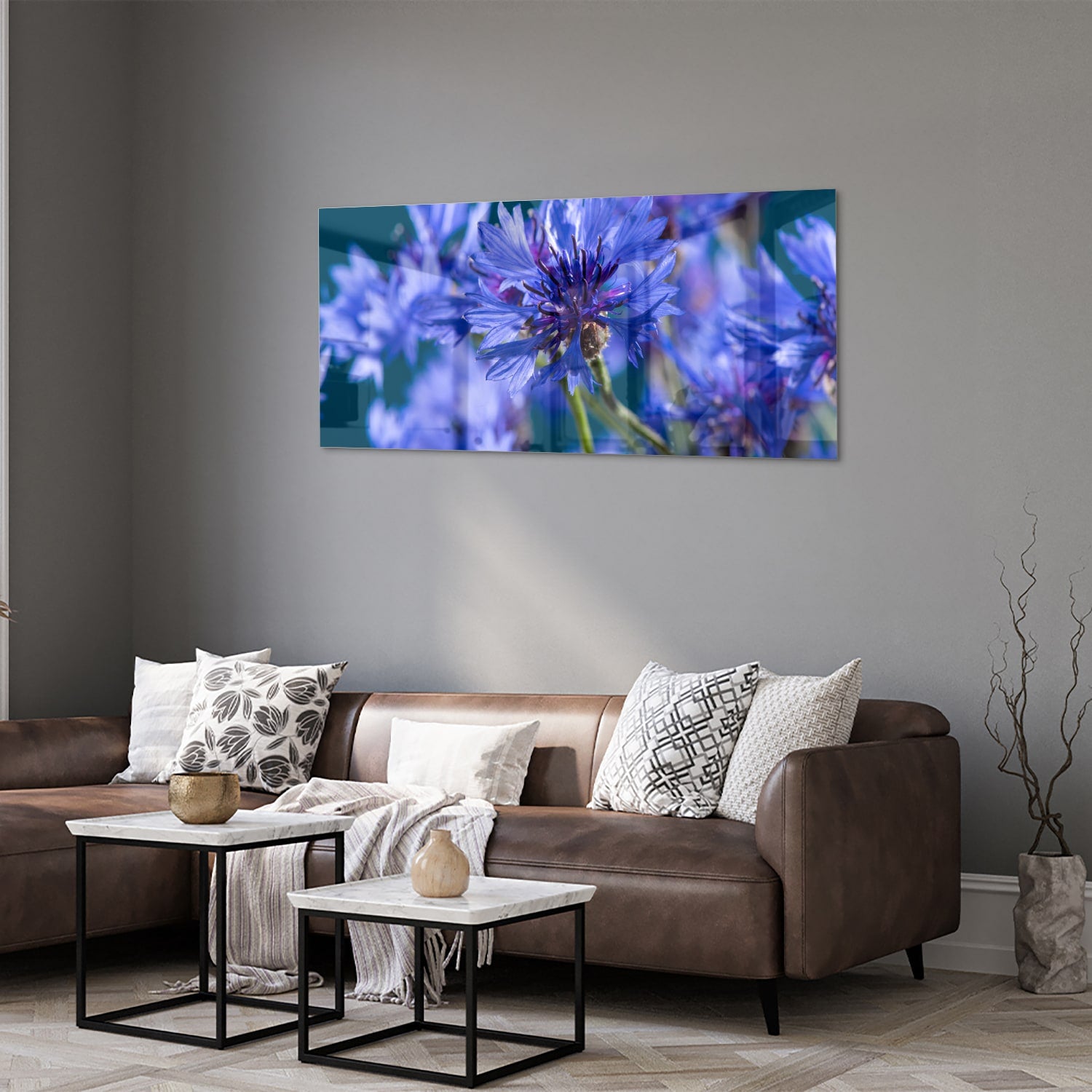Een glazen schilderij met paarse bloemen op een witte muur, in een sfeervolle woonkamer.