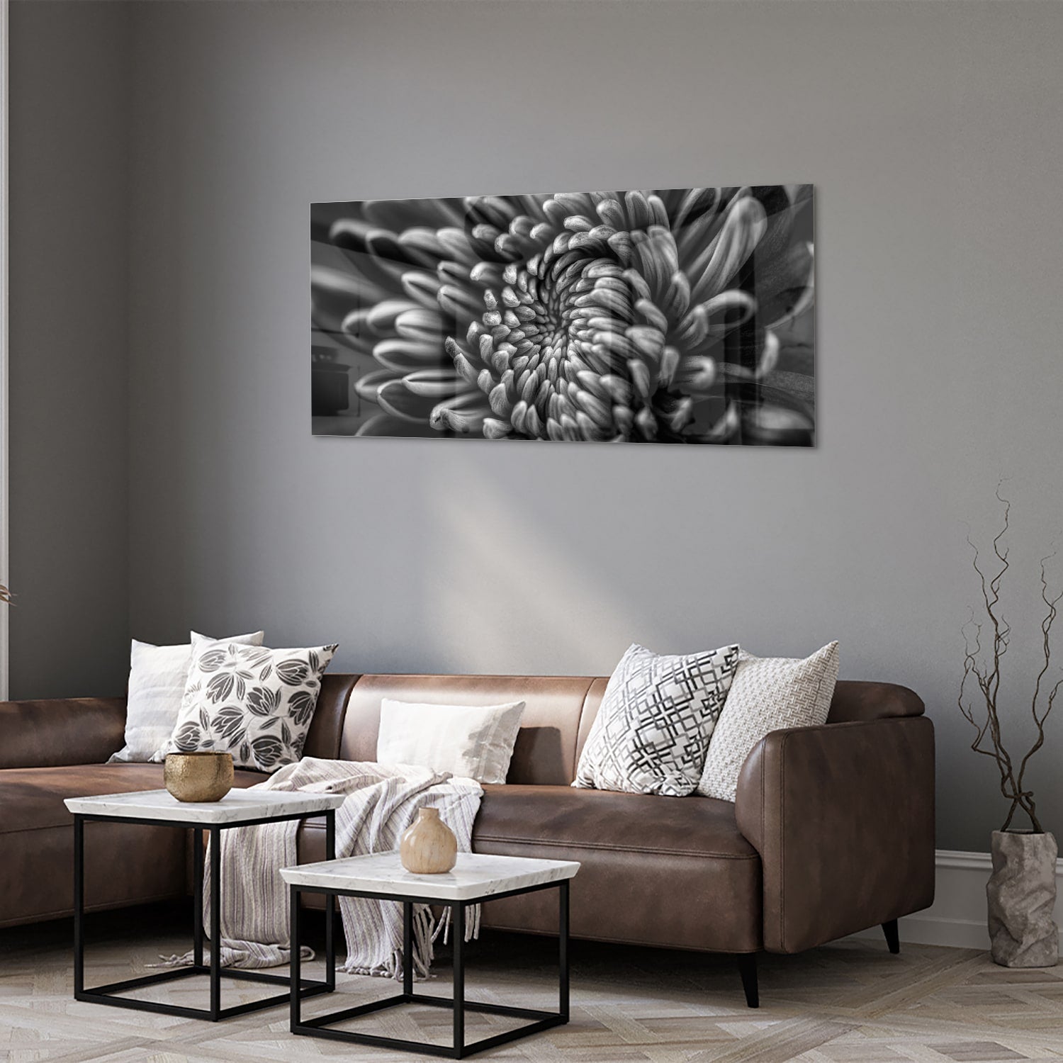 Zwart-wit glas schilderij van een kronkelige bloem aan de muur.