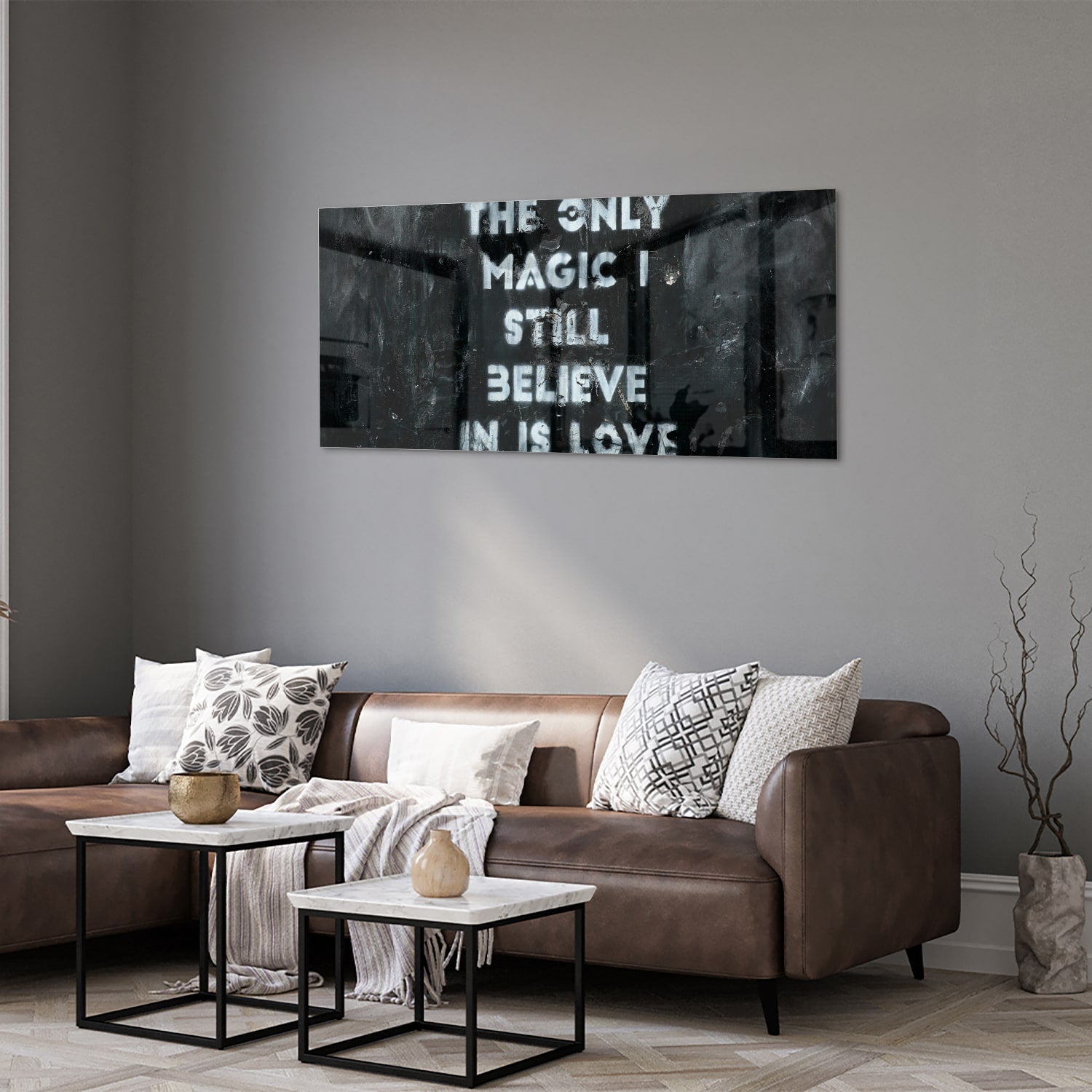 Glazen schilderij met de tekst 'The only magic I still believe in is love', hangt aan de muur in een lichte woonkamer.