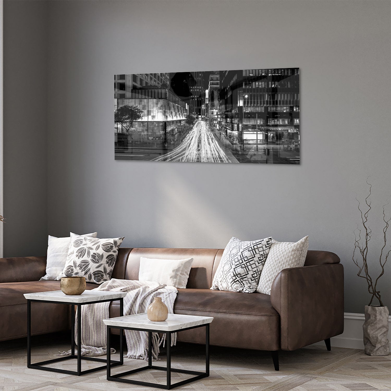 Glazen schilderij met stadslichten in zwart-wit boven een moderne meubelset.