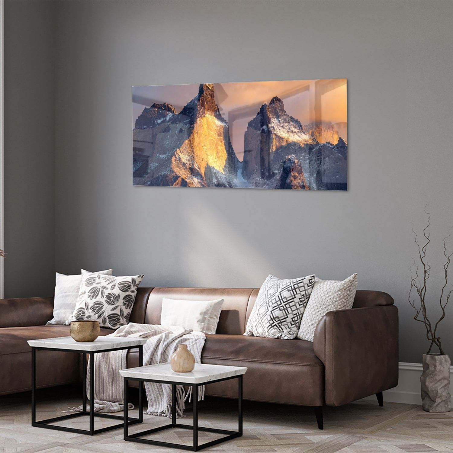 Een glazen schilderij van majestueuze bergen met gouden ochtendlicht