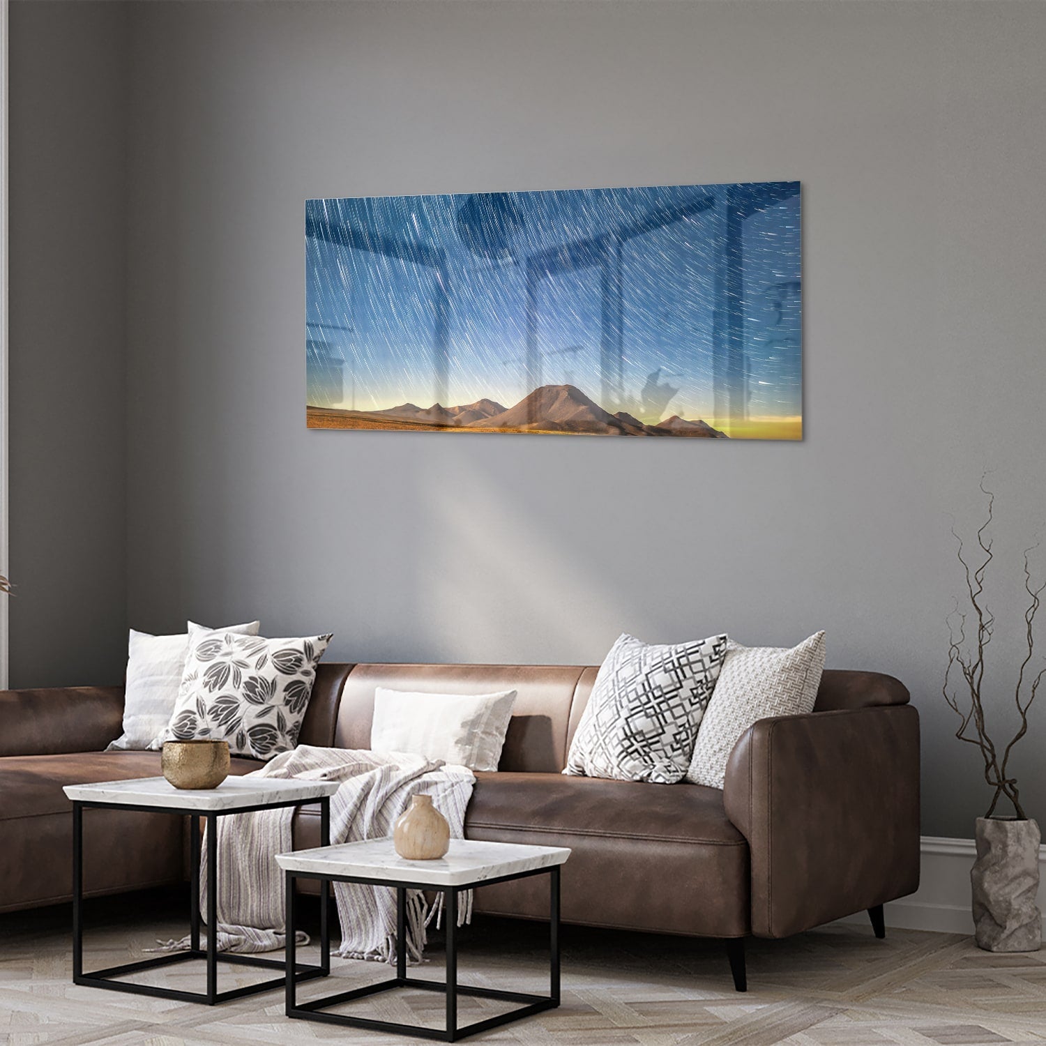 Glazen schilderij met sterrenhemel boven bergen, hangend aan de muur.