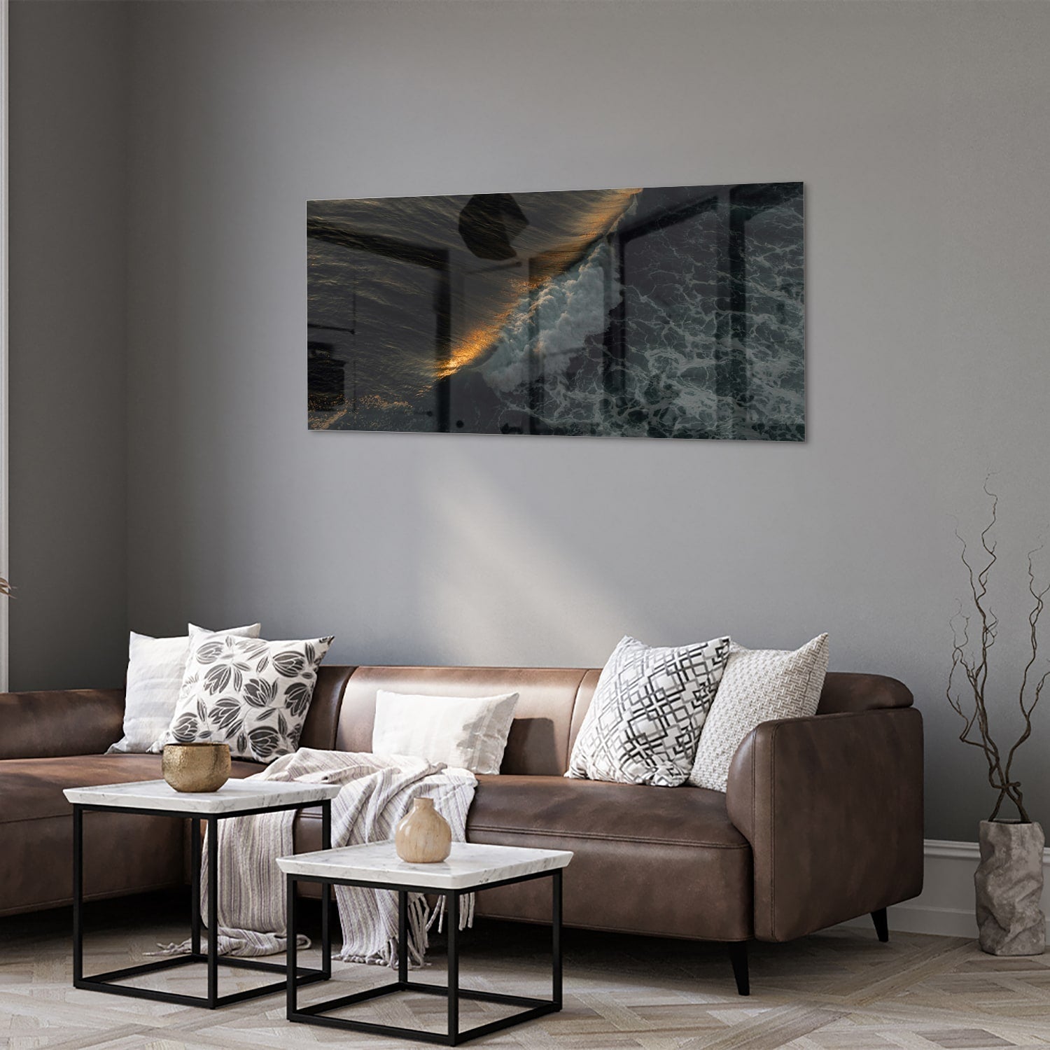 Zwart glazen schilderij van een zeegezicht met gouden accenten, hangt aan een lichtgekleurde muur.