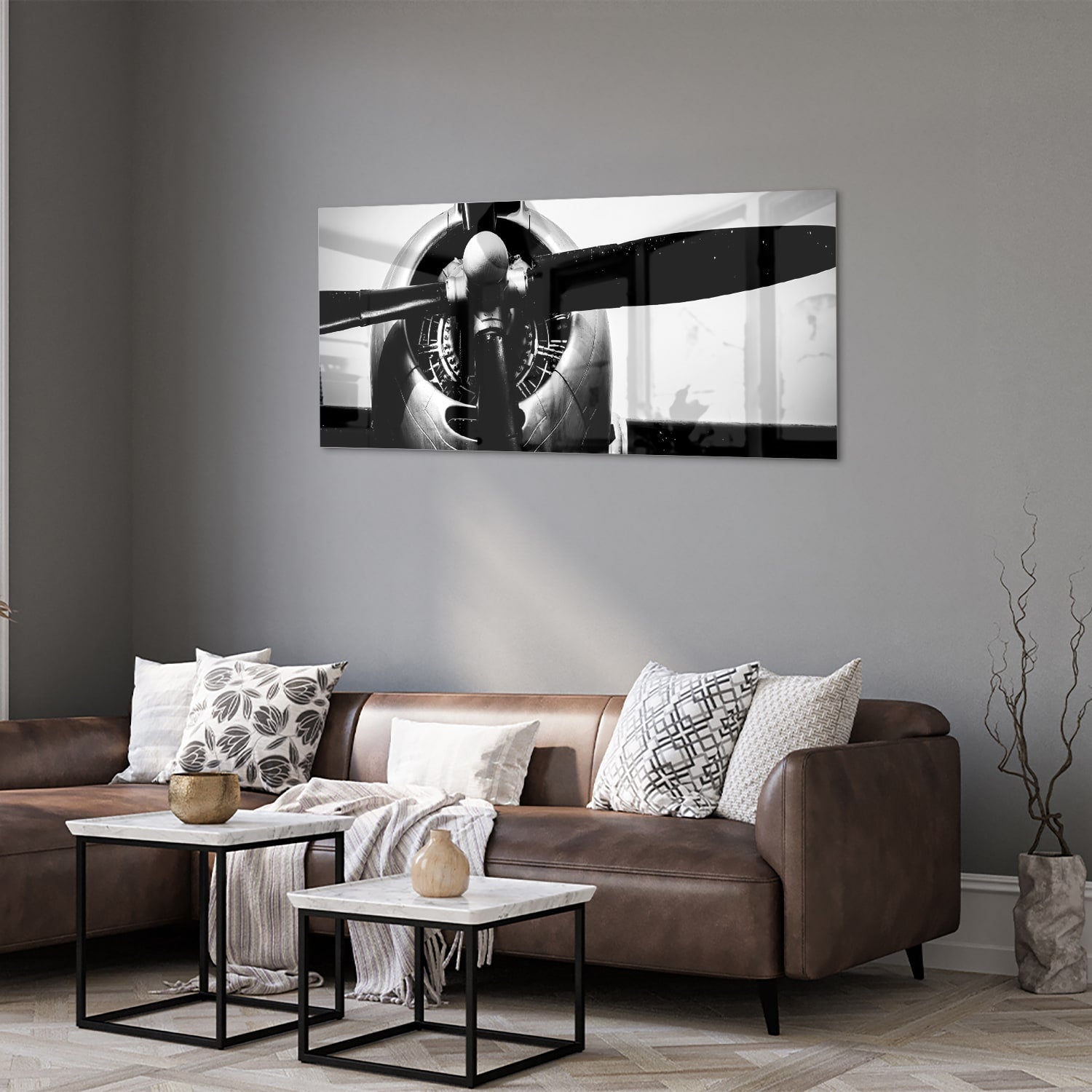 Zwart-wit glazen schilderij van een vintage vliegtuigpropeller tegen een lichte muur.