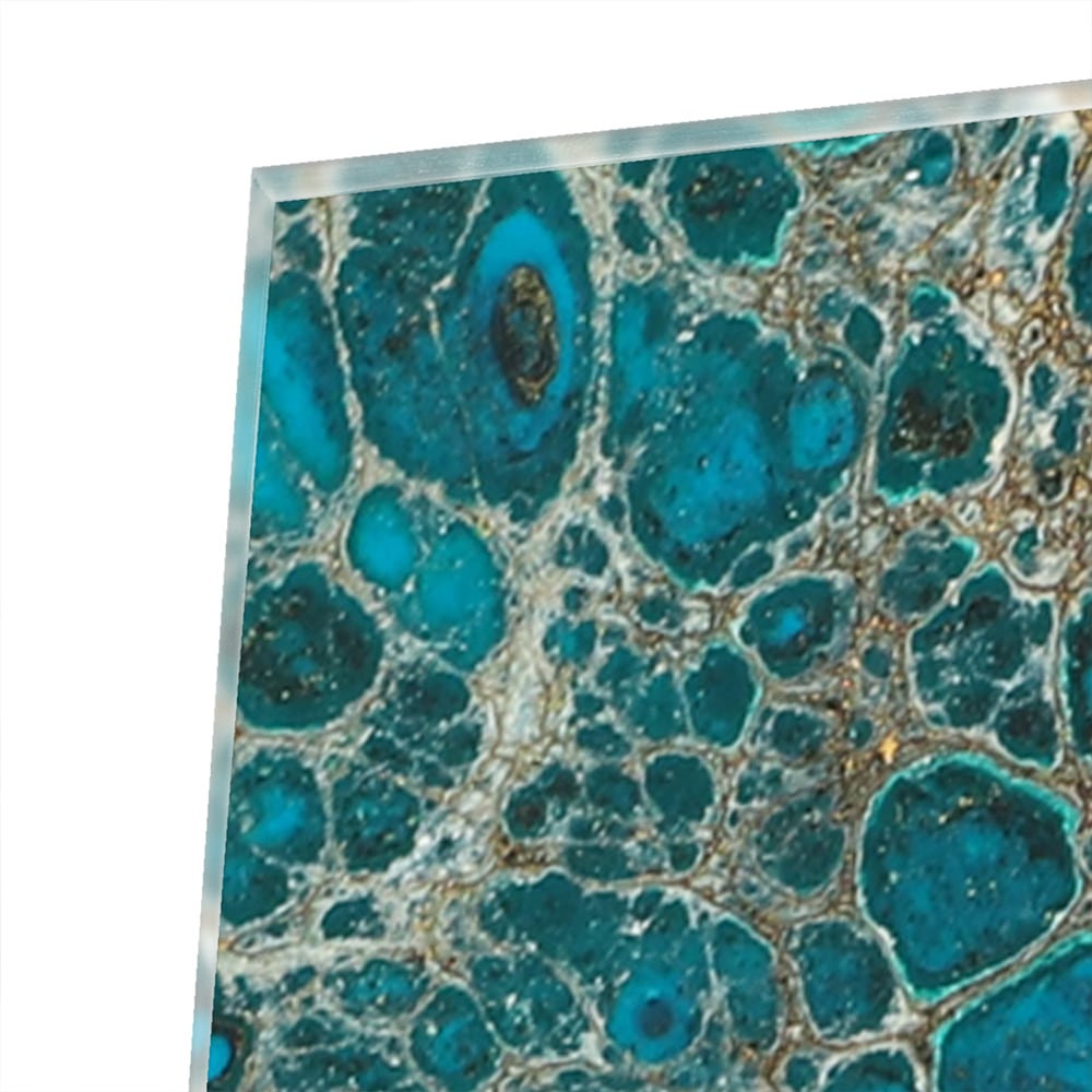 Glazen schilderij in turkoois met gouden accenten aan de muur boven een houten meubel.