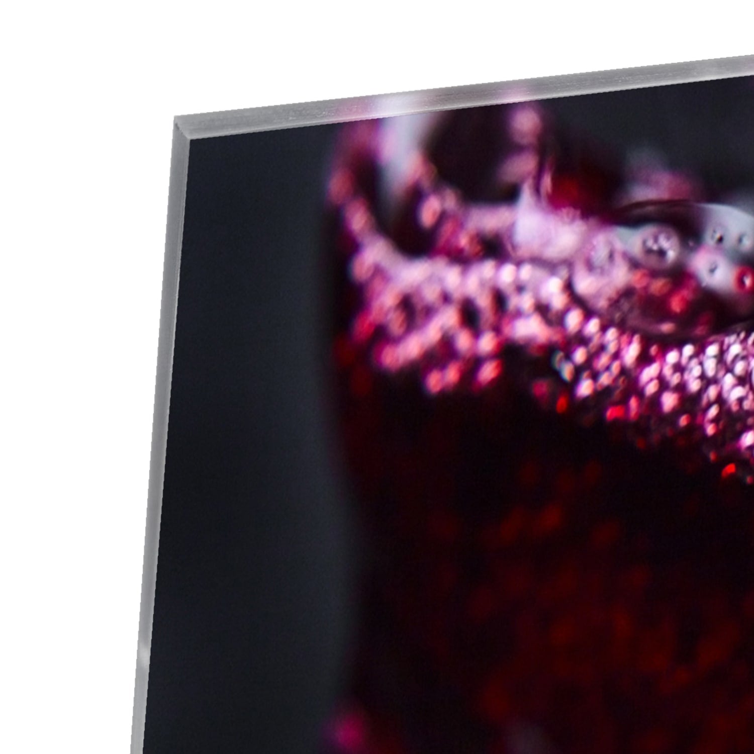 Glazen schilderij met een glas rode wijn en sprankelende druppels.