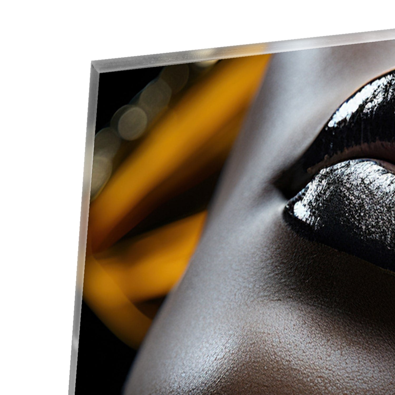 Glazen schilderij van een vrouwelijk gezicht met gouden accenten op een muur.