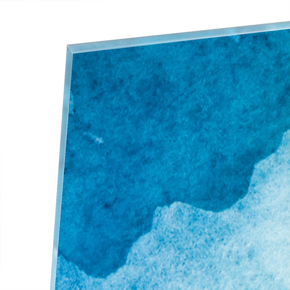 Abstract glazen schilderij in diverse tinten blauw en groen aan de muur.