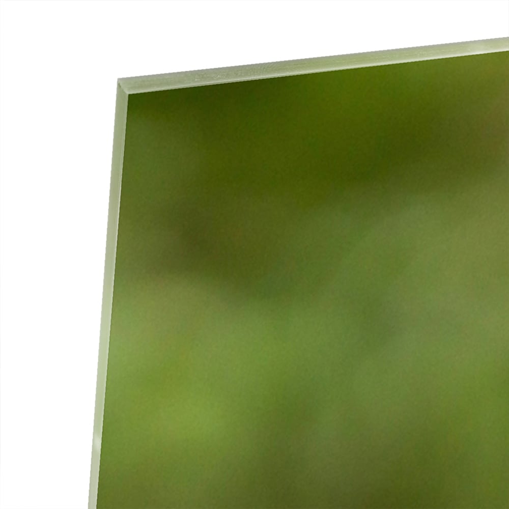 Een glazen schilderij van een kolibrie die vloog voor een groene achtergrond in een lichte kamer.