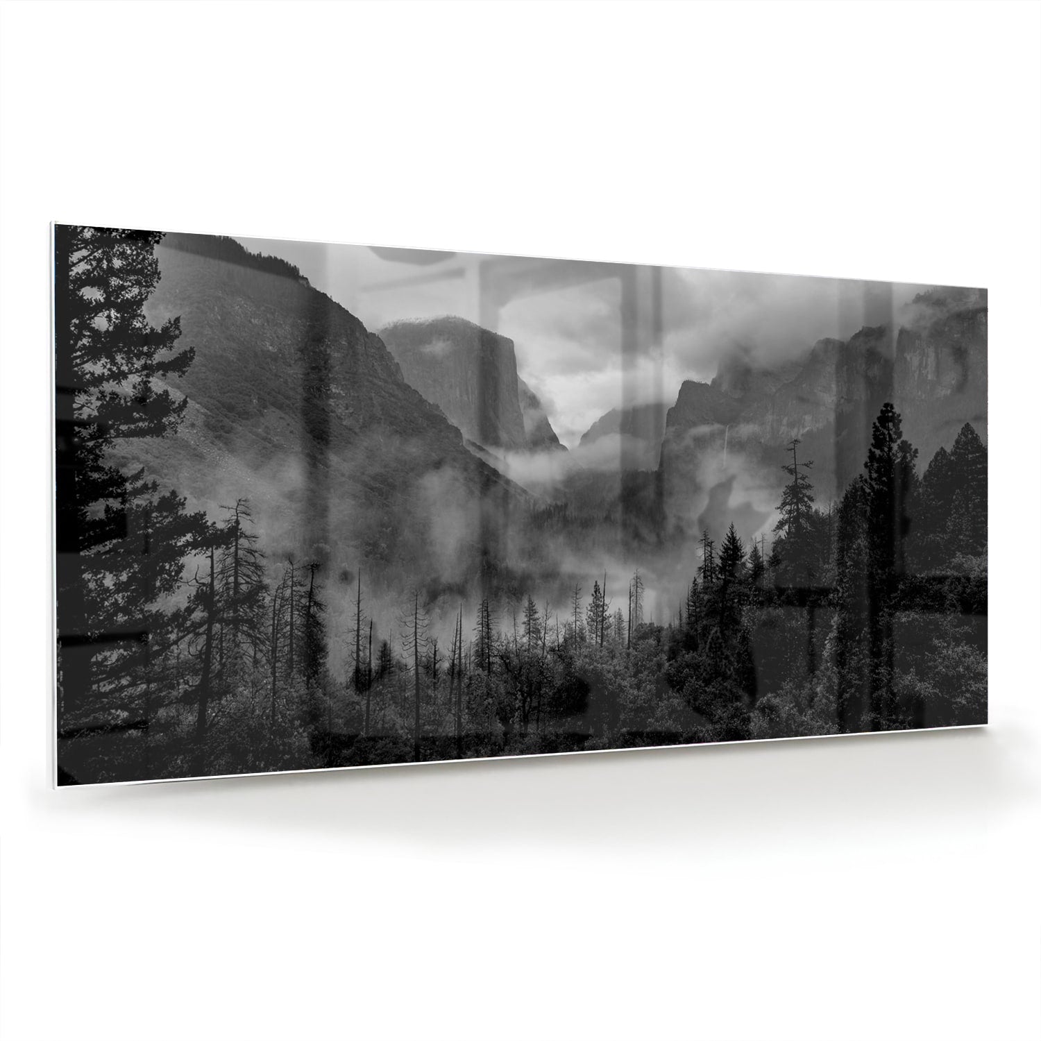 Zwart-wit glazen schilderij van een sereen berglandschap aan de muur.