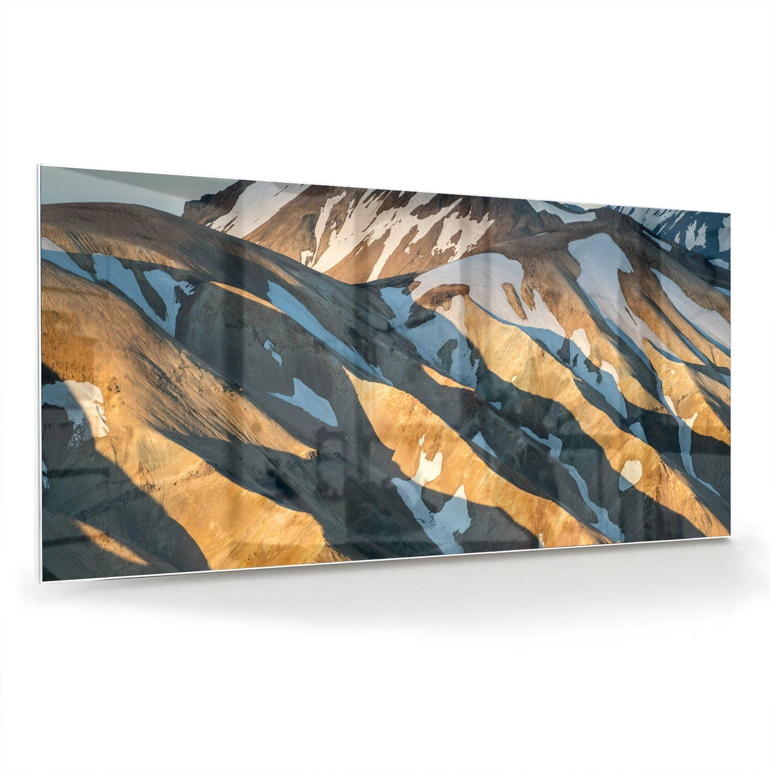 Glazen schilderij van bergen in blauw en goud, hanging in een stijlvolle kamer.