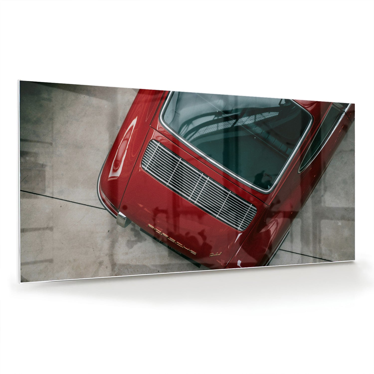 Glazen schilderij van een bovenaf gezien rode auto op een muur.