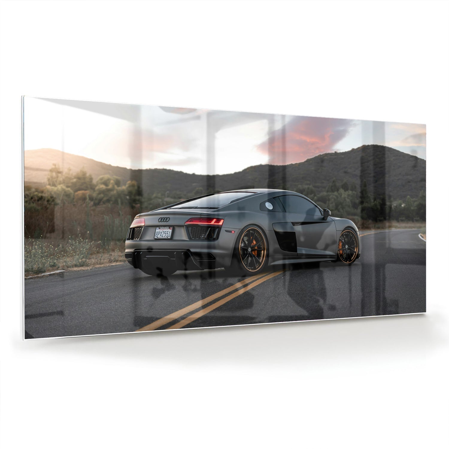 Glazen schilderij van een sportwagen afgebeeld in de natuur met bergen op de achtergrond.