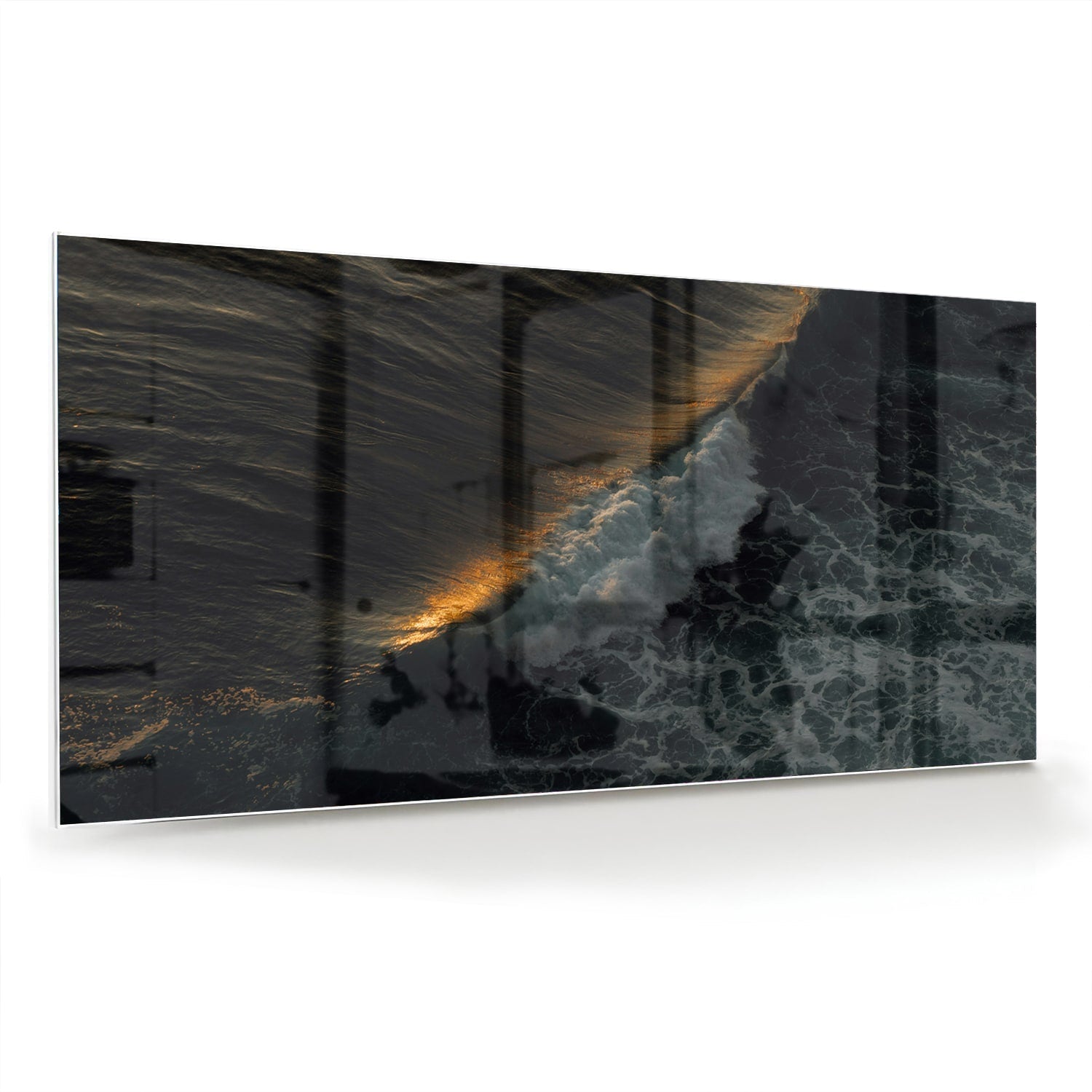 Zwart glazen schilderij van een zeegezicht met gouden accenten, hangt aan een lichtgekleurde muur.