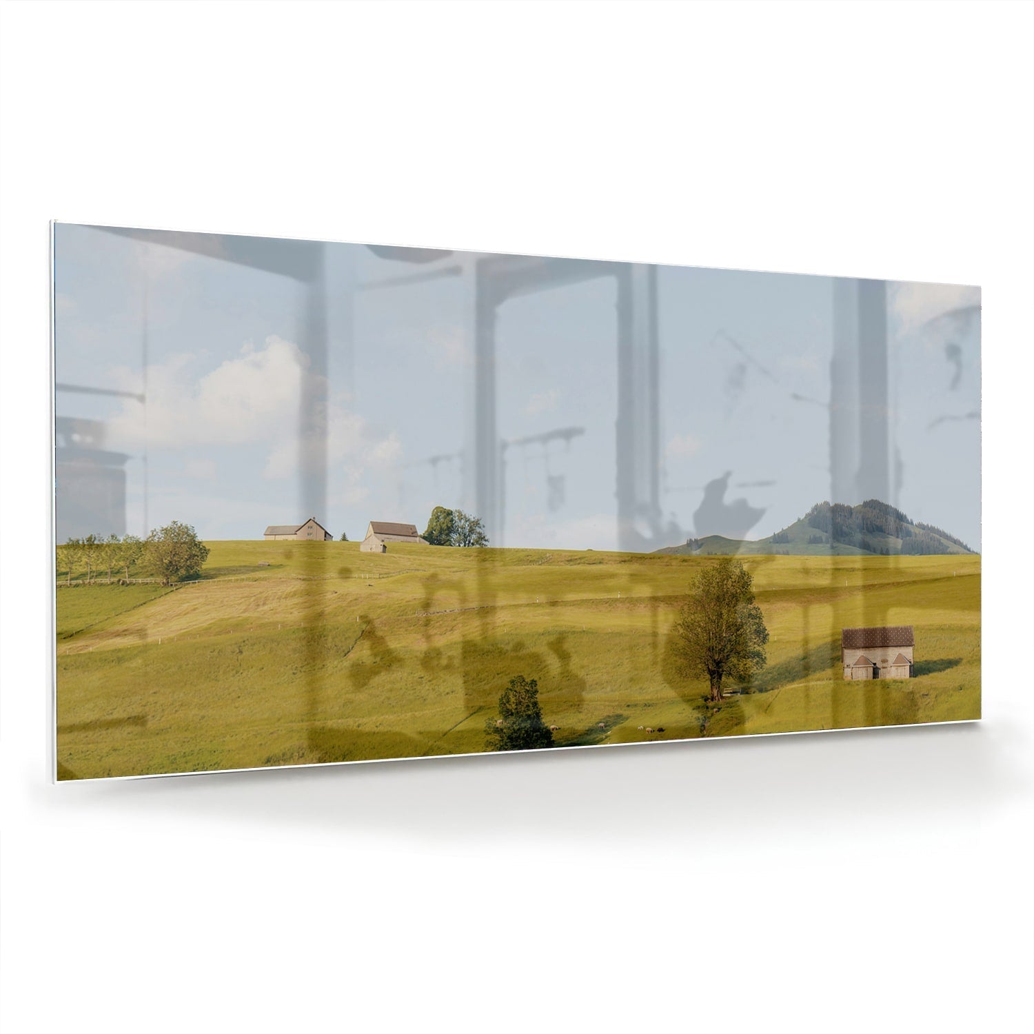 Glazen schilderij met groene heuvels en boerderijen op een witte muur.